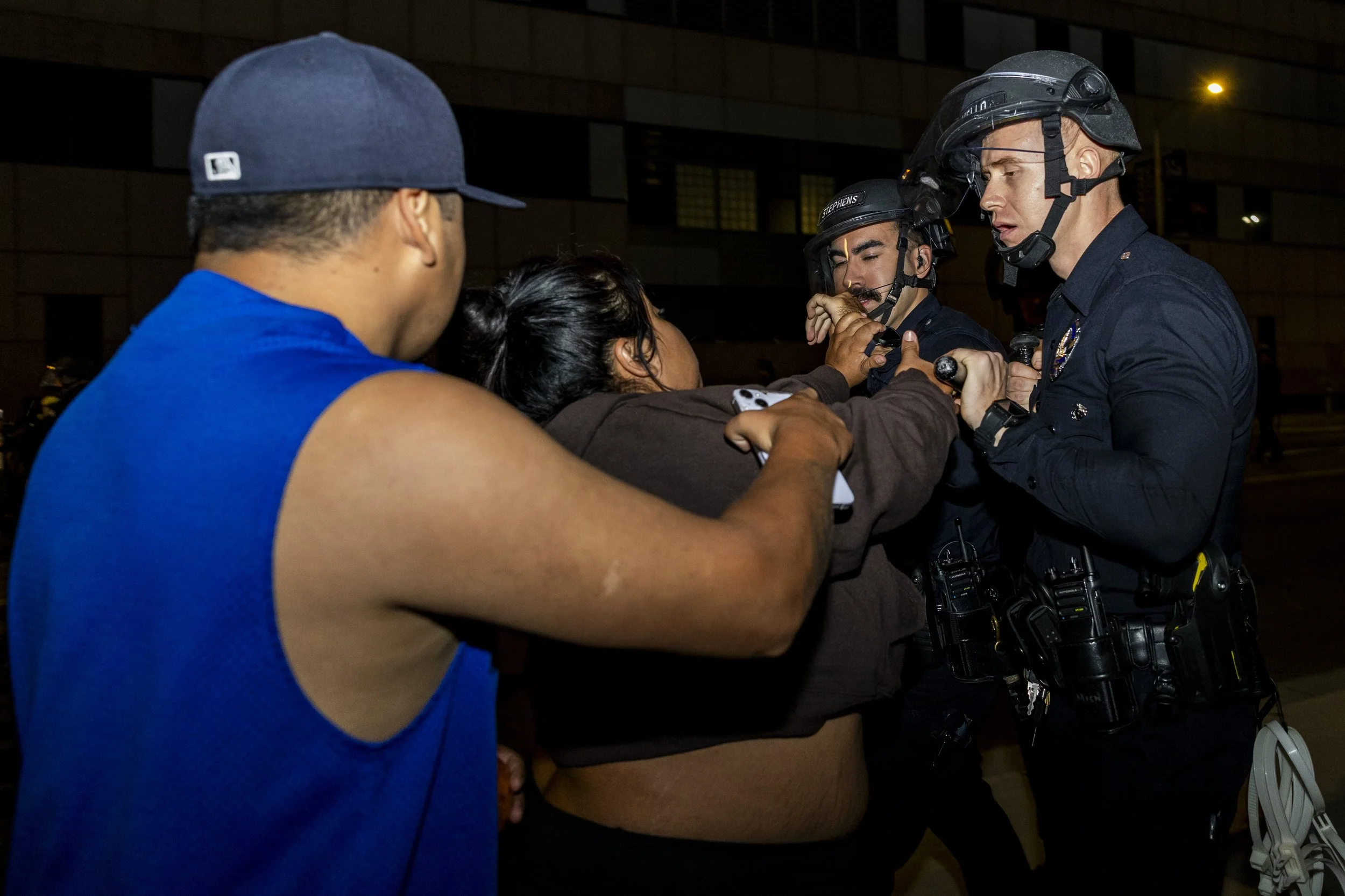 A protester holding his partner back as she pushes an incoming police line at the Metropolitan Detention Center in Los Angeles, Calif., on Monday, Sept. 1, 2025, during an anti-ICE protest. (Kayjel J. Mairena | The Corsair)