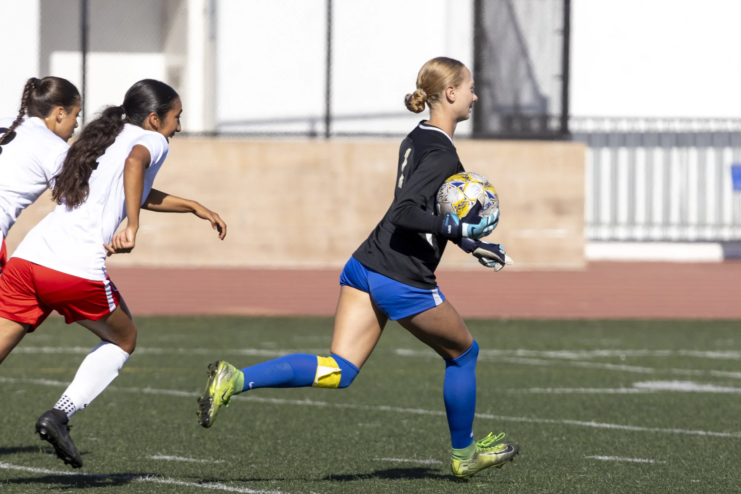 Santa Monica College Corsairs women's soccer goalkeeper Jacinda Hevesy-Rodriguez (#1) returns the ball to her teammates, pursued by forward Emily Diaz (#14) of the Pierce College Brahmas, Tuesday, September 9, 2025. The Corsairs beat the Brahmas, 1-