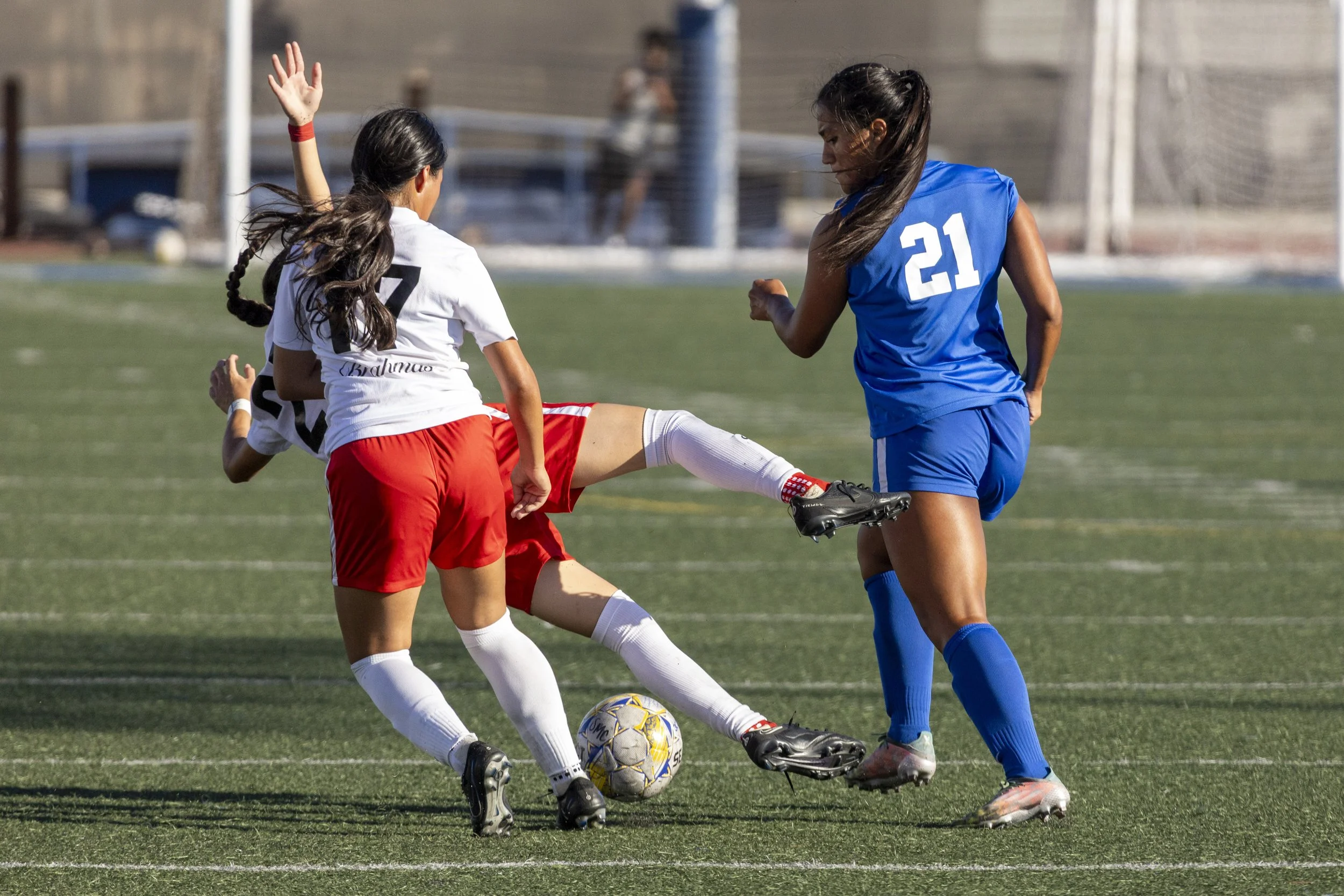 Forward Jocelyn Coronado (#21) of the Pierce College Brahmas, with Brahmas defender Stephany Ramirez (#17) in tow, takes a fall after being pursued by Santa Monica College Corsairs defender Adriana Maldonado (#21), on Tuesday, September 9, 2025, at