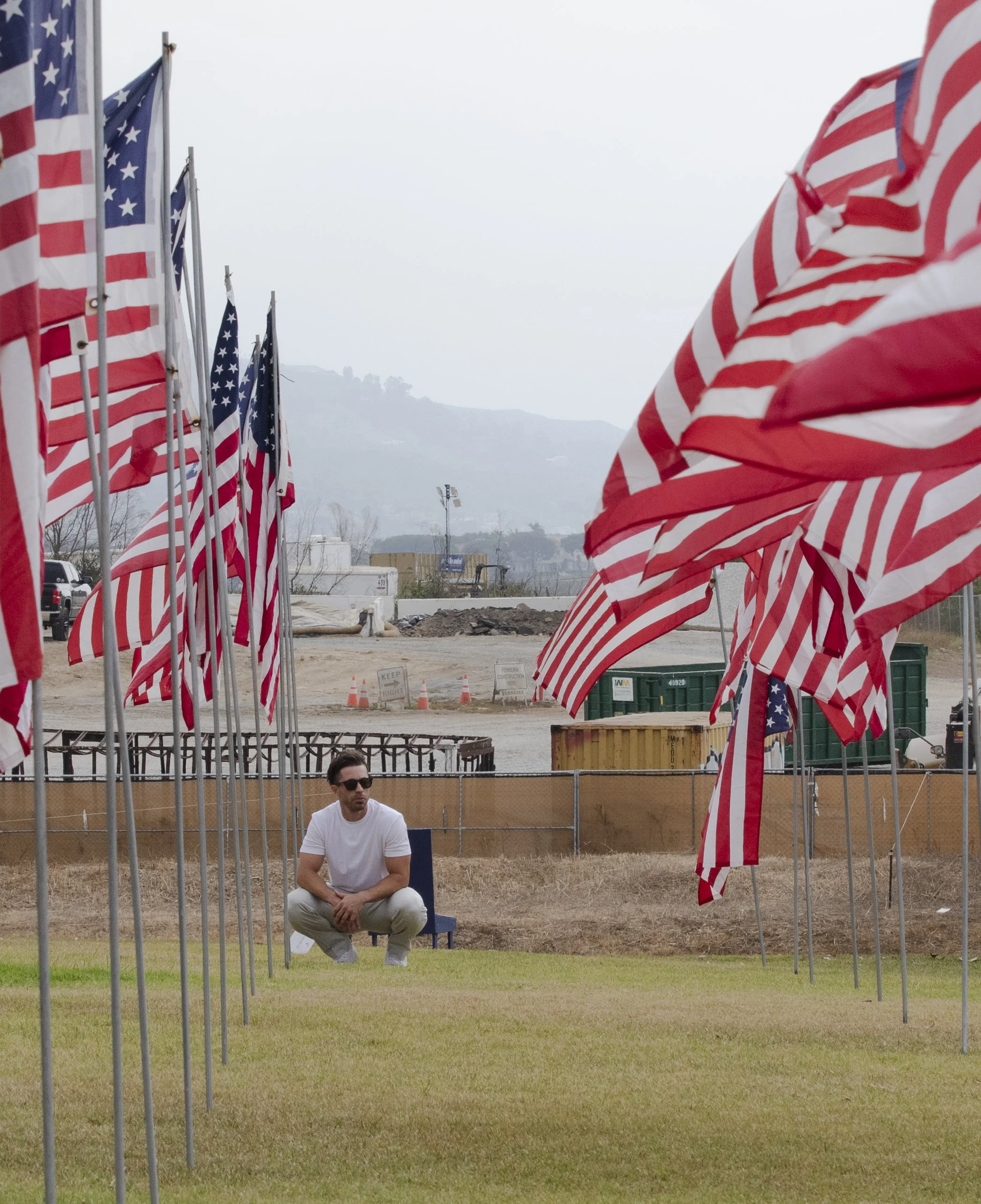 David Ferrugio visits the “Waves of Flags” installation of nearly 3000 flags, one for each victim of 9/11, displayed on the hills of Pepperdine University against the backdrop of the construction from the Palisade fire on Thursday, Sept 11, 2025 at