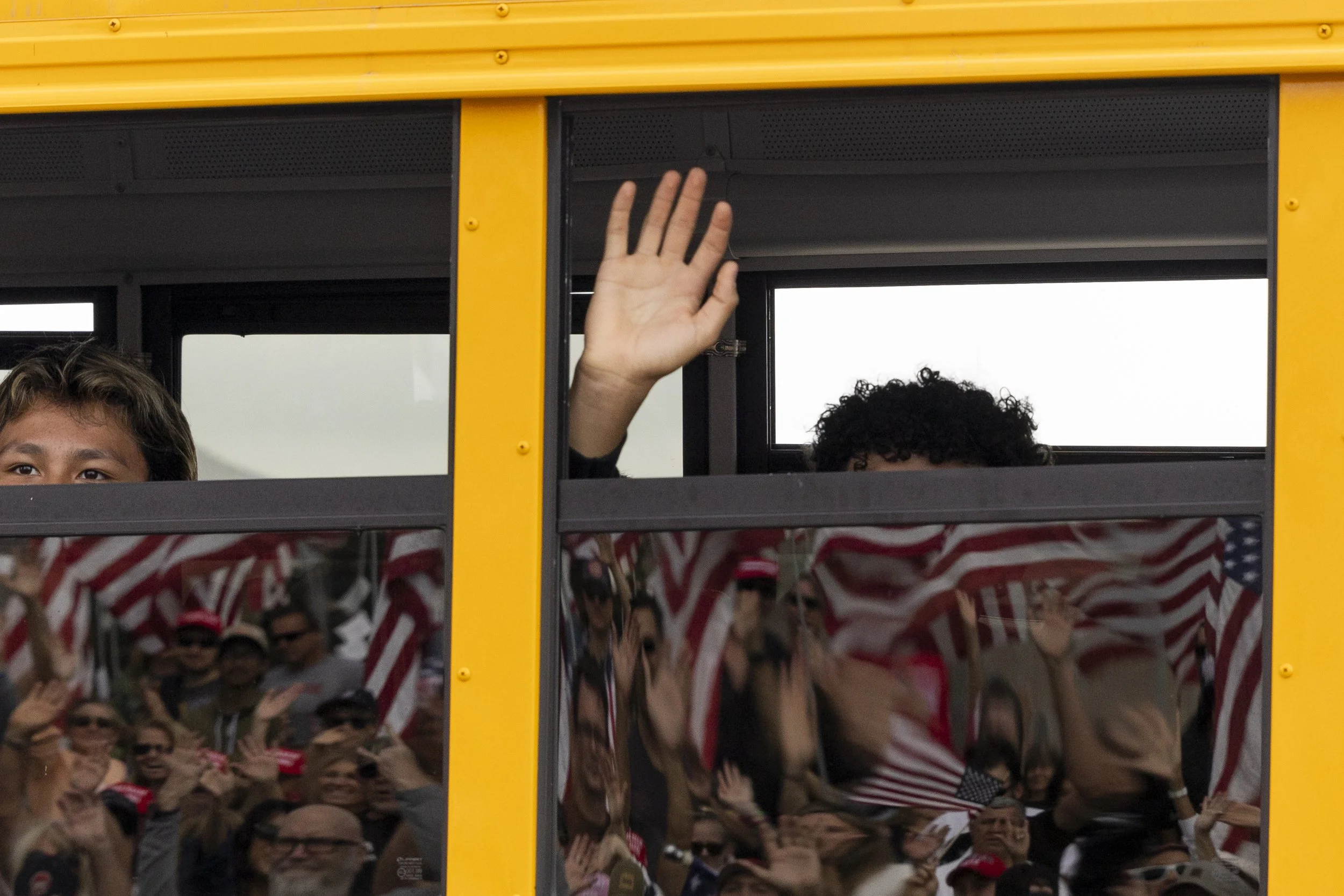 Children in a school bus wave and stare at the 805 Patriots, a pro-Maga group, who gathered at Pepperdine University in Malibu, Calif., on Saturday, Sept. 13, 2025, for a remembrance cruise dedicated to the victims of 9/11 and Charlie Kirk.(Jake Cra
