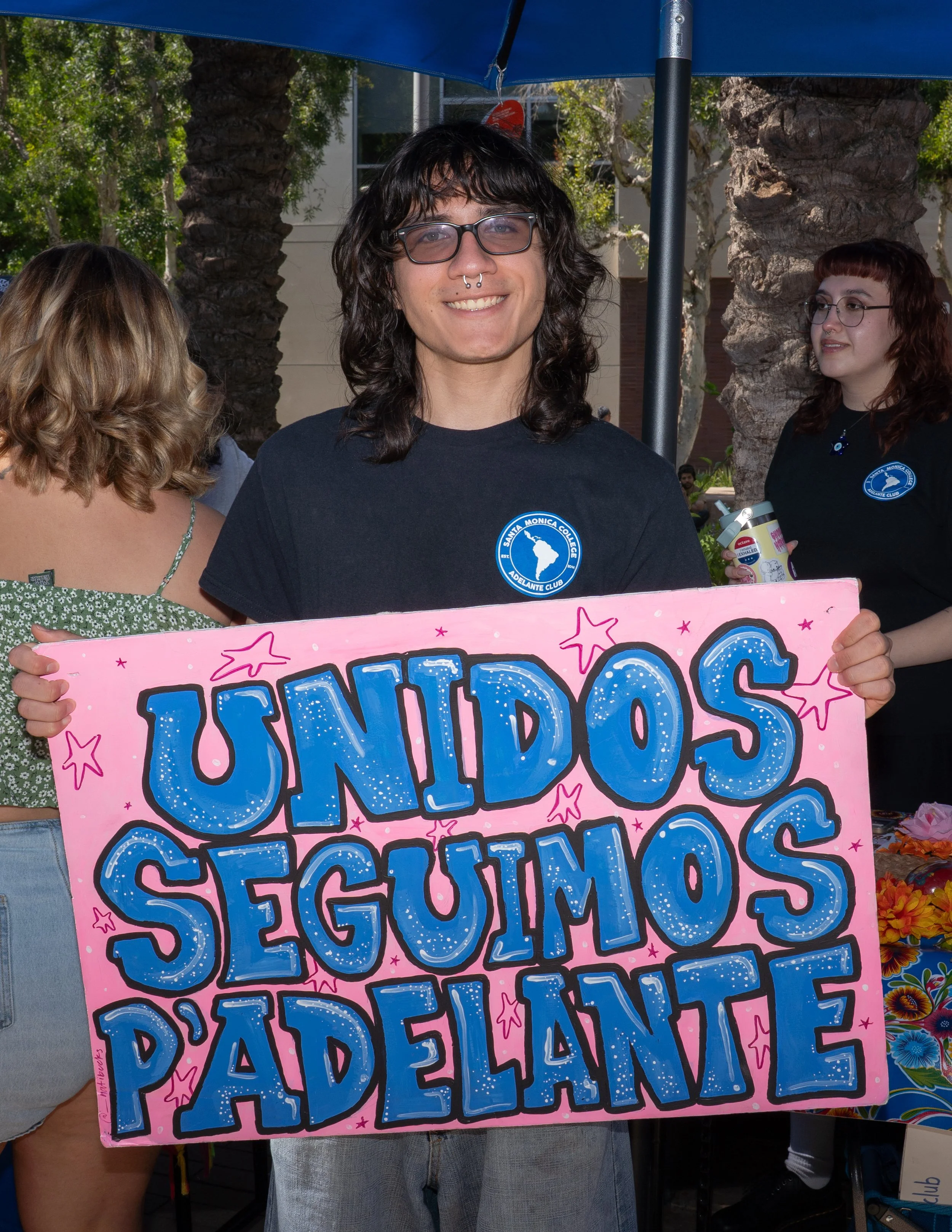 Santa Monica College (SMC) Adelante Club President Abby, holds up a sign at the SMC Start Up on Tuesday September 16 in Santa Monica, Calif. The sign, written in spanish, translates to "united together, we keep moving forward". The Adelante Club pro