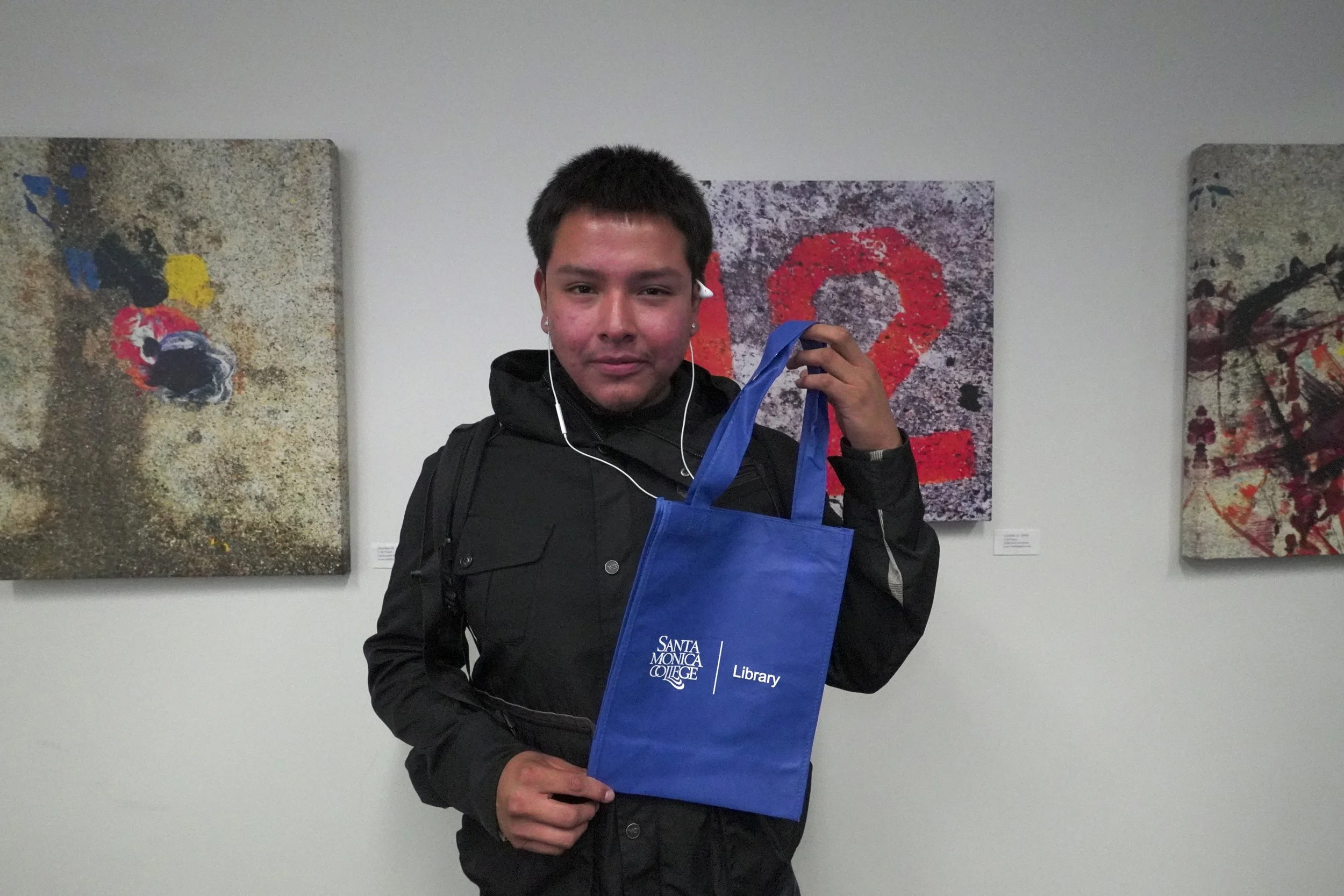Alan Perez, a returning Santa Monica College (SMC) student holds up a gifted SMC library tote bag at the Coffee with Librarians event that provides coffee and donuts to students on Thursday, Sept. 18, 2025 at SMC, in Santa Monica, Calif. (Ciara Burr