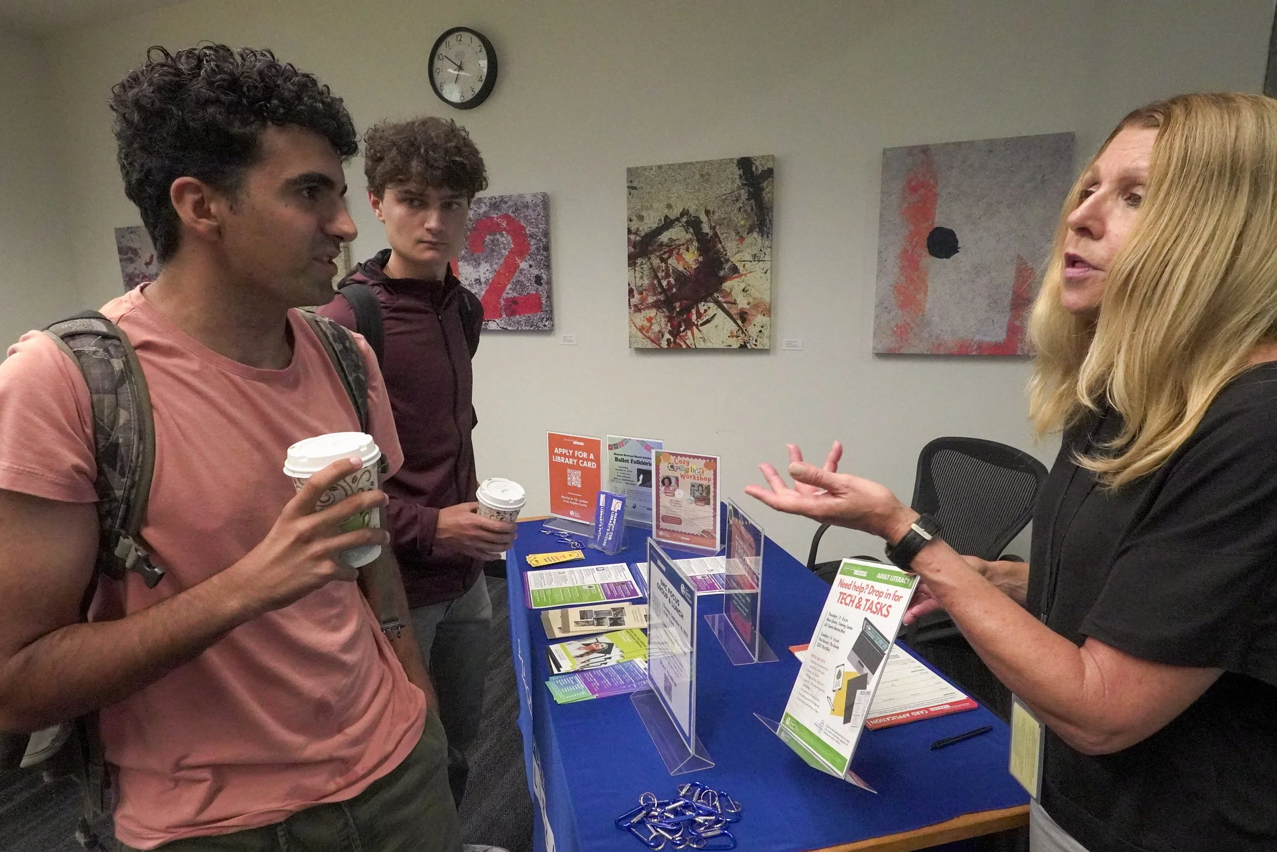 Noah Sarah (left), Benjamin Eisen (Center) Santa Monica College (SMC) students received Tech & Tasks information from Santa Monica Public librarian Karen Reitz (right) at the Coffee with Librarians event on Thursday, Sep. 18, 2025 at SMC, in Santa M