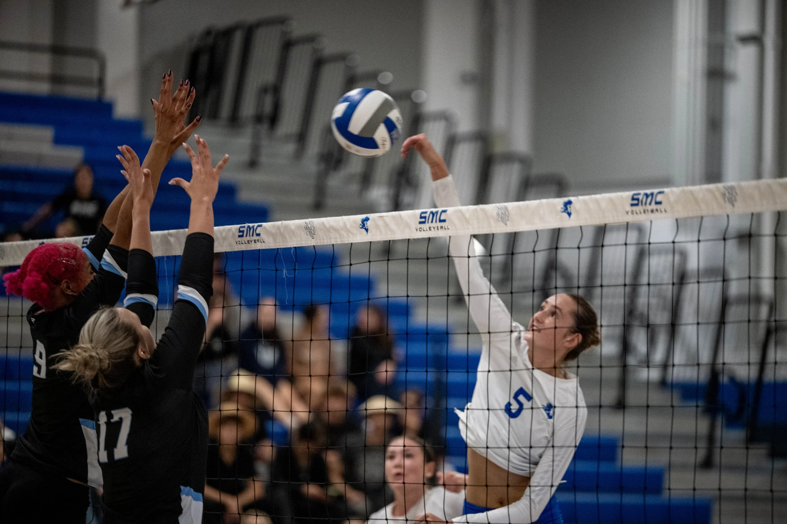 Santa Monica College (SMC) Corsair middle blocker (5) Nicole Lankton spiking the ball past Moorpar defense (L to R) middle blocker (9) Genessa Johnson and outside hitter (17) Hailey Byron on Friday, September 19, 2025, Santa Monica,Calif. The Corsai