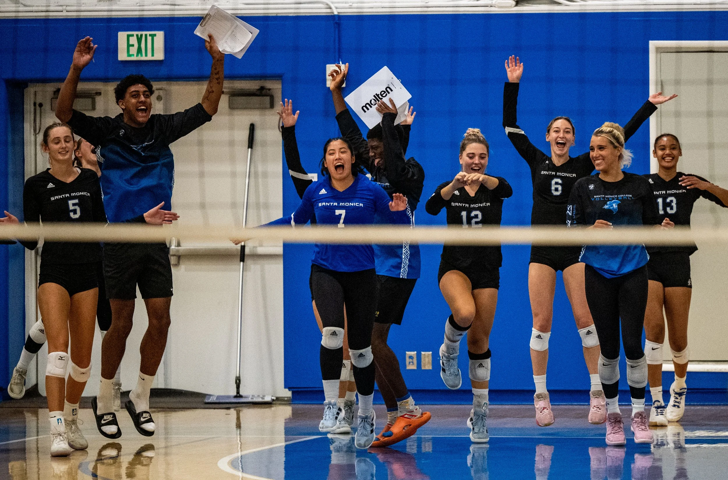 Santa Monica College (SMC) Corsairs teammates and assistant coaches celebrate after winning second set on Friday, September 19, 2025, Santa Monica,Calif. The Corsairs won the match 3-0. (Tom Rosholt | The Corsair)