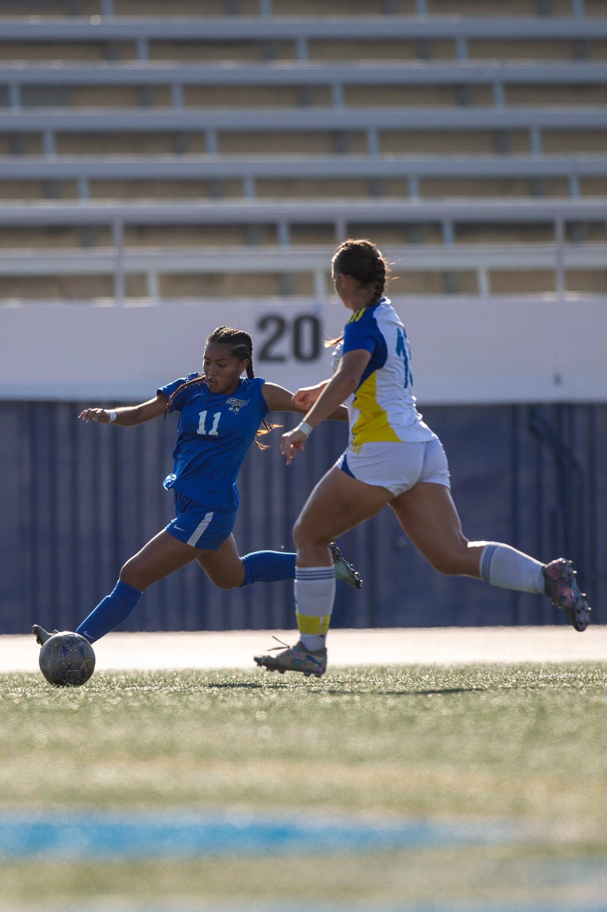 Santa Monica College (SMC) Corsair forward Erika Bautista (#11) crosses the ball to a teammate while West LA College Wildcats defender Ella Lucas (#13) during a match at SMC Corsair Stadium, Santa Monica, Calif, on Sept 30th, 2025. SMC Corsair defea