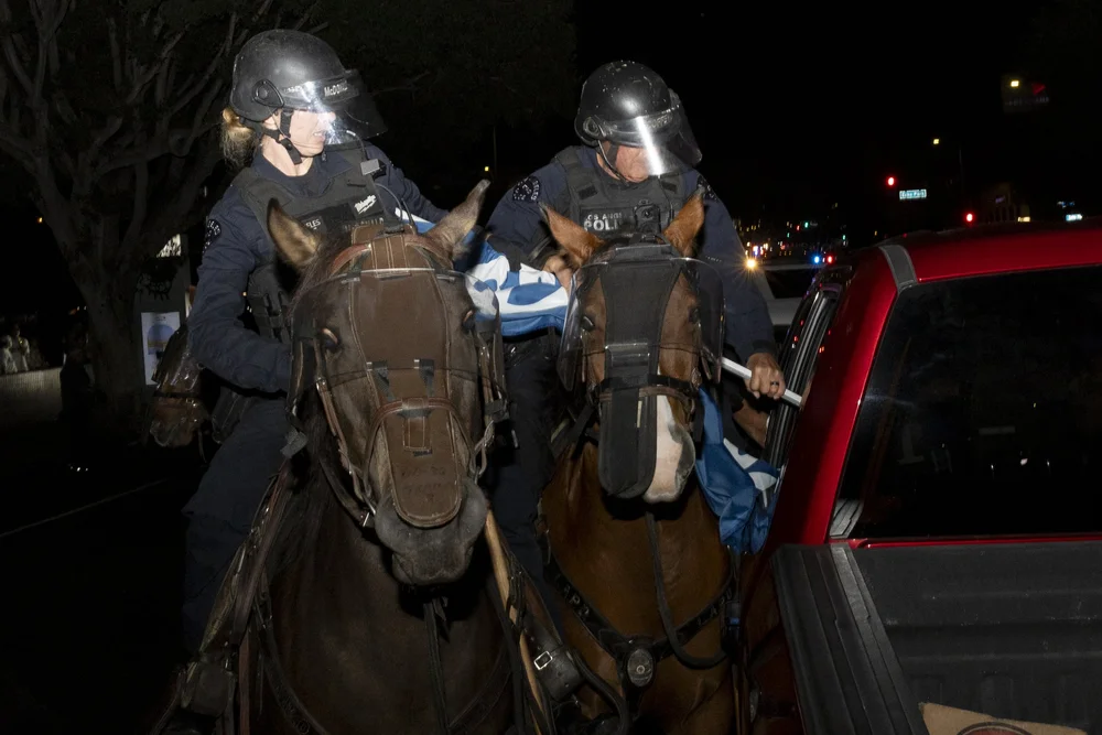  Los Angeles Police Department mounted officers rip a Dodgers flag out of a vehicle that’s stuck in traffic during a street takeover on Echo Park Avenue and Sunset Boulevard in Los Angeles, on Saturday, Nov. 1, 2025, after Game 7 of the MLB World Ser