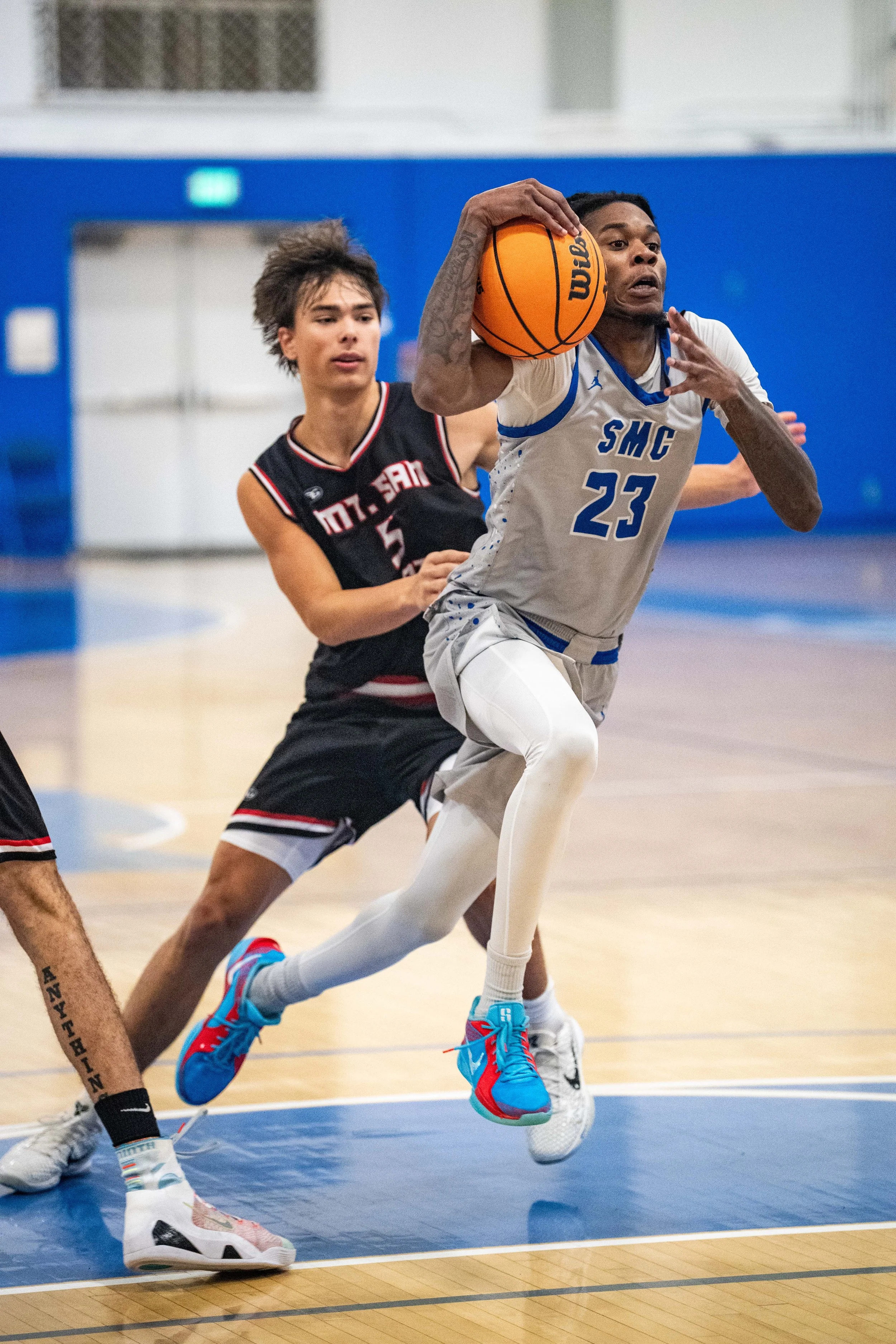  Santa Monica College (SMC) Corsair guard (23) Jerrell McCready drives the ball to the net passed  San Jacinto College Rave (5) Daniel Crawford on Saturday, Nov. 8, 2025, Santa Monica,Calif. Corsairs were defeated by the Raven 83-81. (Tom Rosholt | T
