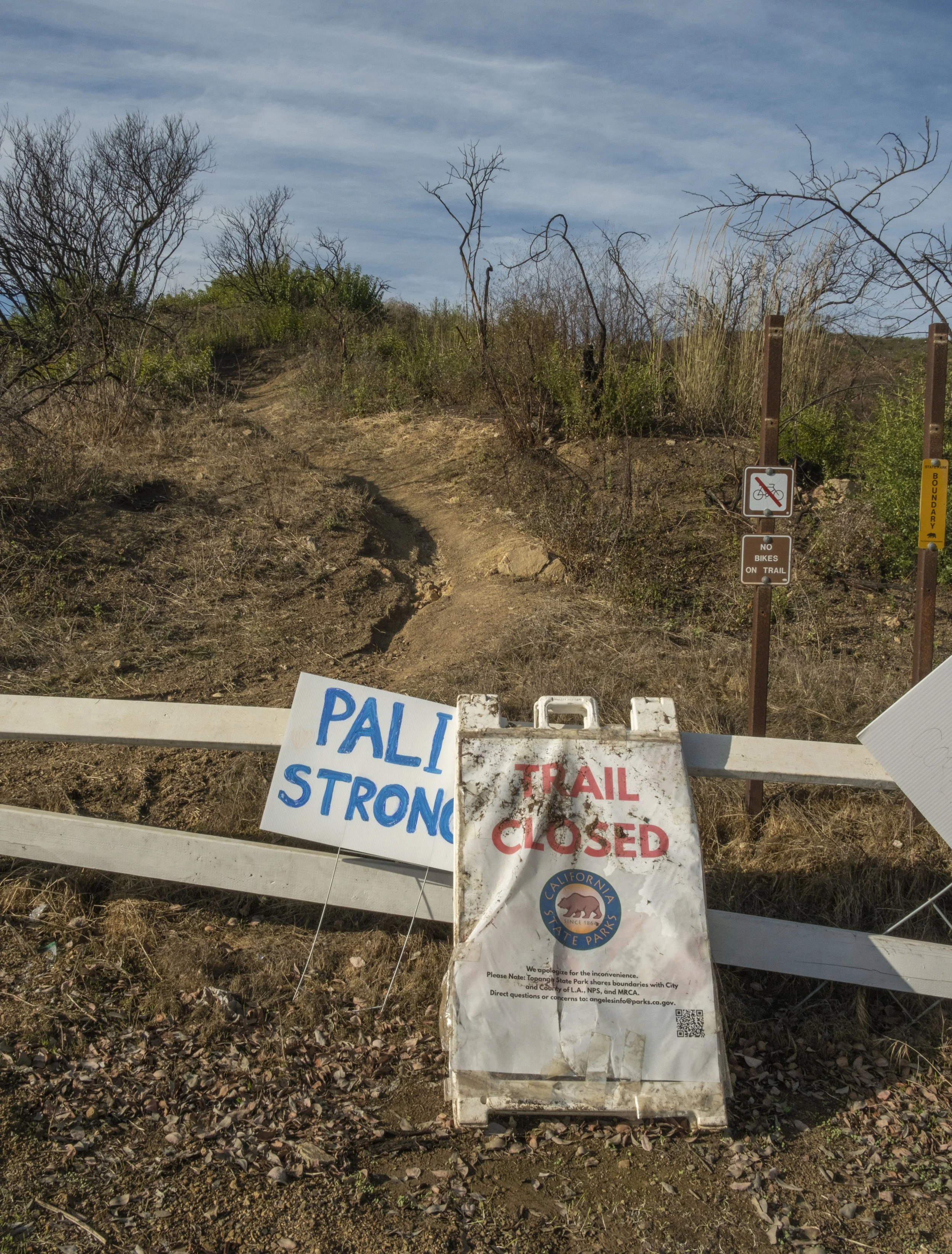  A “Trail Closed “ sign stands next to a “Pali Strong” on Sunday, Oct. 19, 2025, at theTrailhead of the Temescal Ridge Trail, Pacific Palisades neighborhood of Los Angeles, Calif., which connects to the Skull Rock Trail -- the place where the Lachman