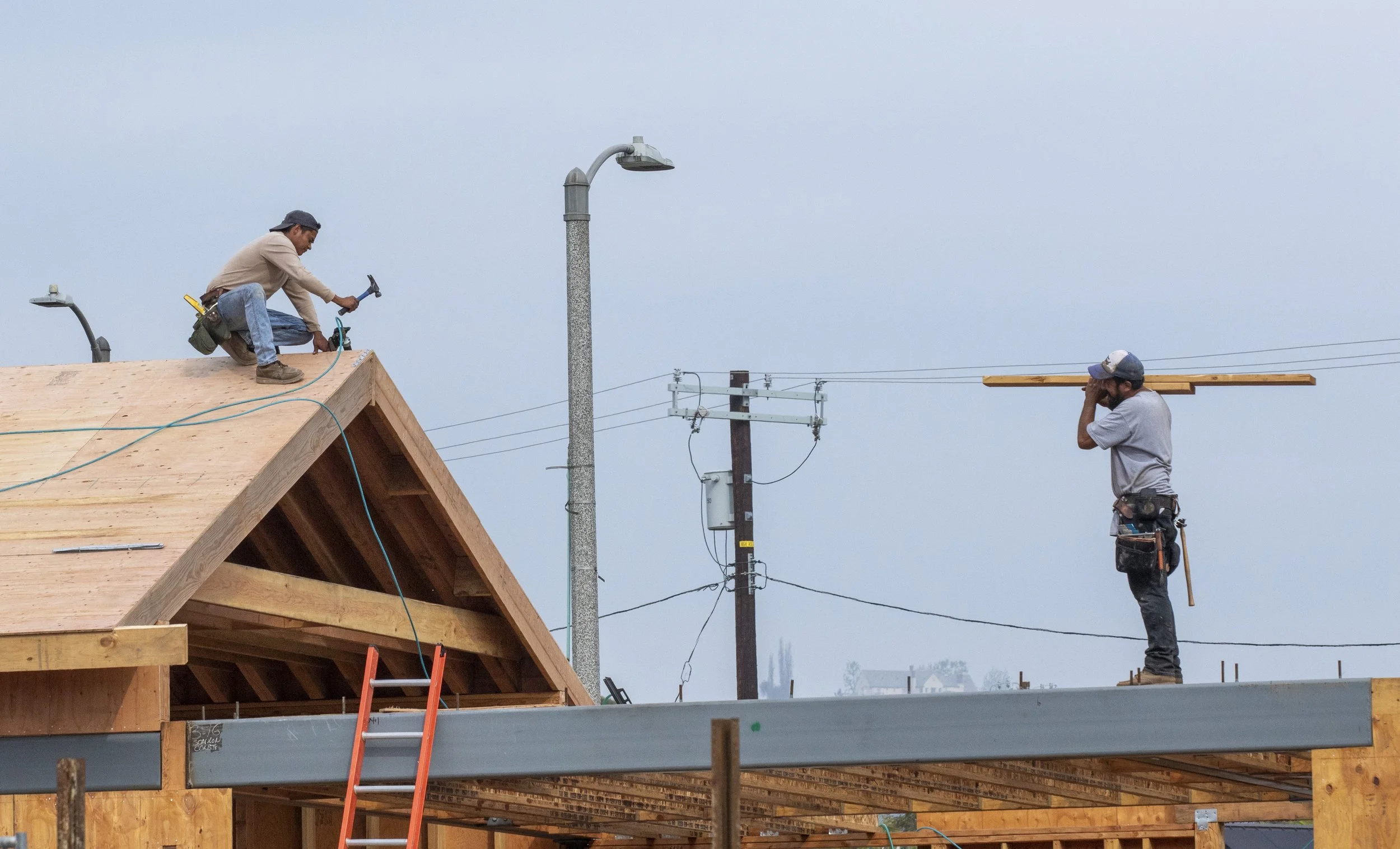  Construction men work on the rooftop of a house frame after the Palisades Fire in Pacific Palisades neighborhood of Los Angeles, Calif. on Wednesday, Nov. 12, 2025.  After eight months of debris cleanup, Palisadians are beginning to rebuild.  (Fai F