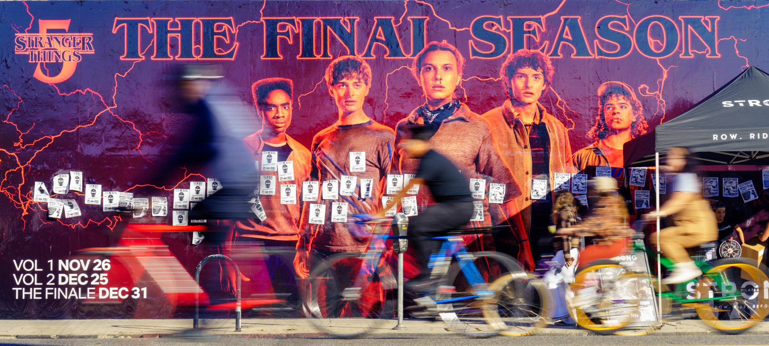  Cyclists ride past a poster for Season 5 of Netflix's Stranger Things on a car-free Melrose Avenue during Netflix x CicLAvia - Melrose Ave: Stranger Things 5 “One Last Ride” event on Sunday, Nov. 23, 2025, in Los Angeles, Calif. The event celebrated