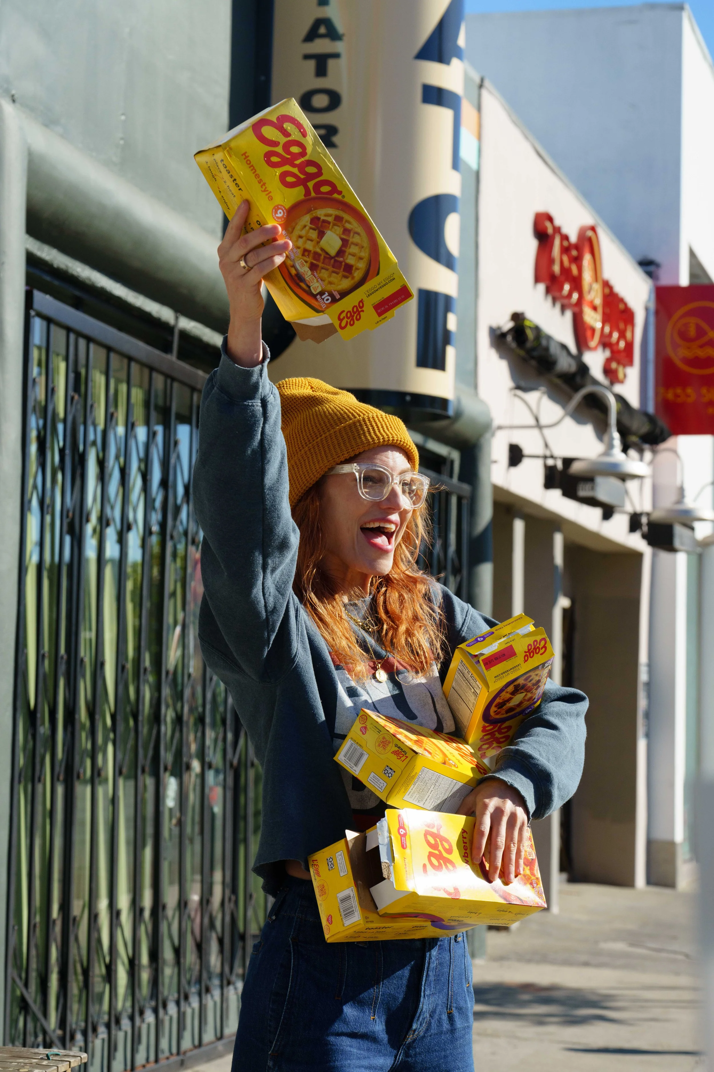  Diana Gettinger holds up Eggo waffle boxes to passing cyclists and Stranger Things fans during Netflix x CicLAvia - Melrose Ave: Stranger Things 5 “One Last Ride” event on Sunday, Nov. 23, 2025, outside Melrose Umbrella Company in Los Angeles, Calif
