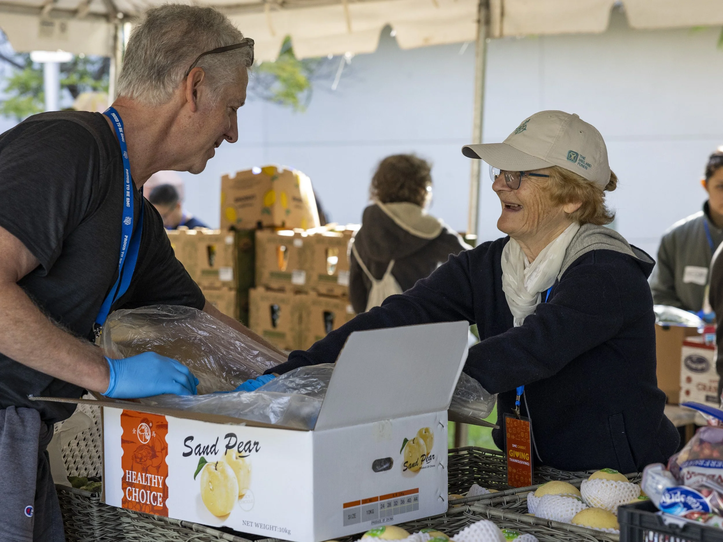  Eric Minzenberg (Left) and Sue O’ Brien (Right) pack peaches at Santa Monica College (SMC) Foundation’s “Giving Thanksgiving” food drive at the college in front of the Cayton Center at SMC in Santa Monica, Calif. Monday, Nov. 24, 2025, to help fight