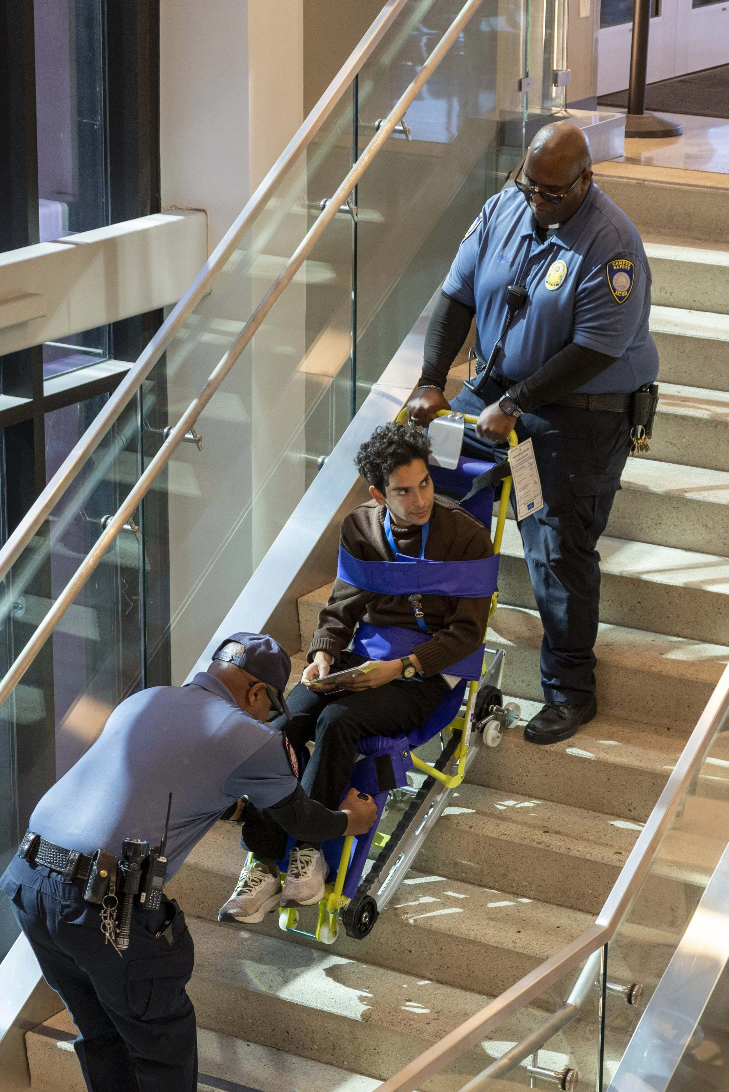  Santa Monica College (SMC) Police officers help {} down the stairs as he is "rescued" from the Student Services Center at SMC in Santa Monica, Calif., during the Great Shake-out earthquake drill on Thursday, Oct. 16, 2025. During the drill, some vol