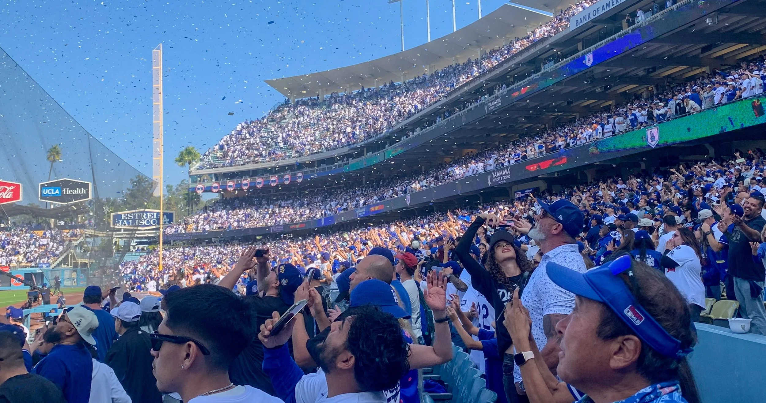  Dodger fans looking up and taking pitcher as confetti flies by them, some fans trying to catch some in Los Angeles, Calif., on Monday, Nov 3 2025, (Rafael Lopez | The Corsair) 