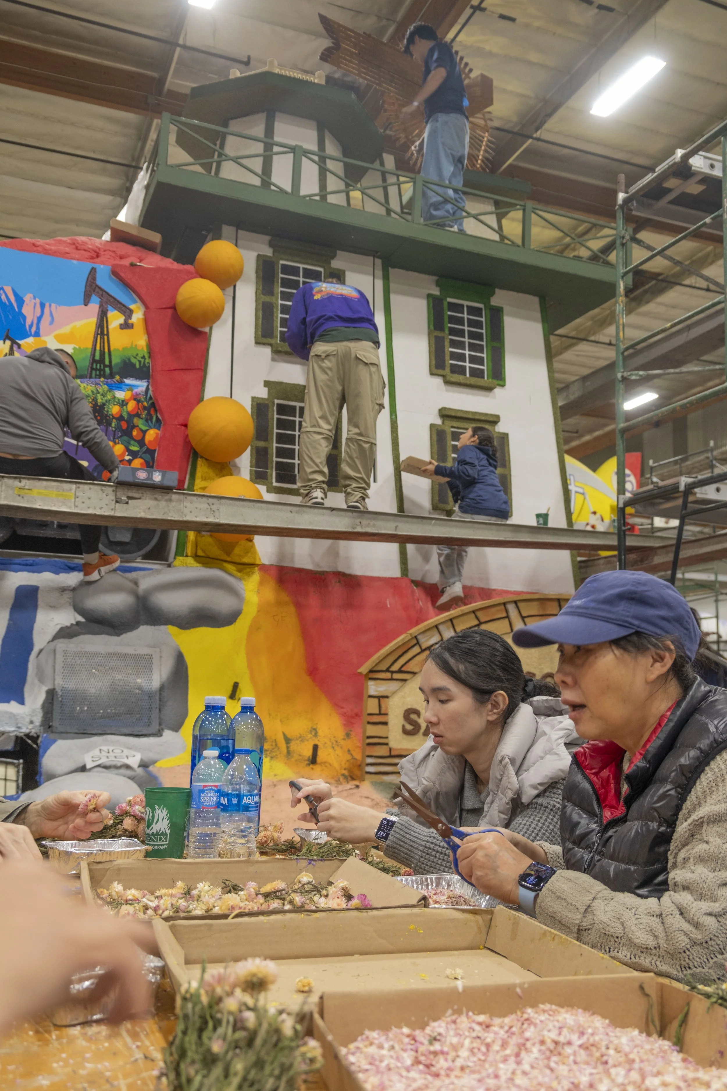  Volunteers cut dried flower petals to create covering material for a Rose Parade float on Friday, Dec 26, 2025 at a warehouse in Irwindale, Calif.  (The Corsair | Fai Fong) 