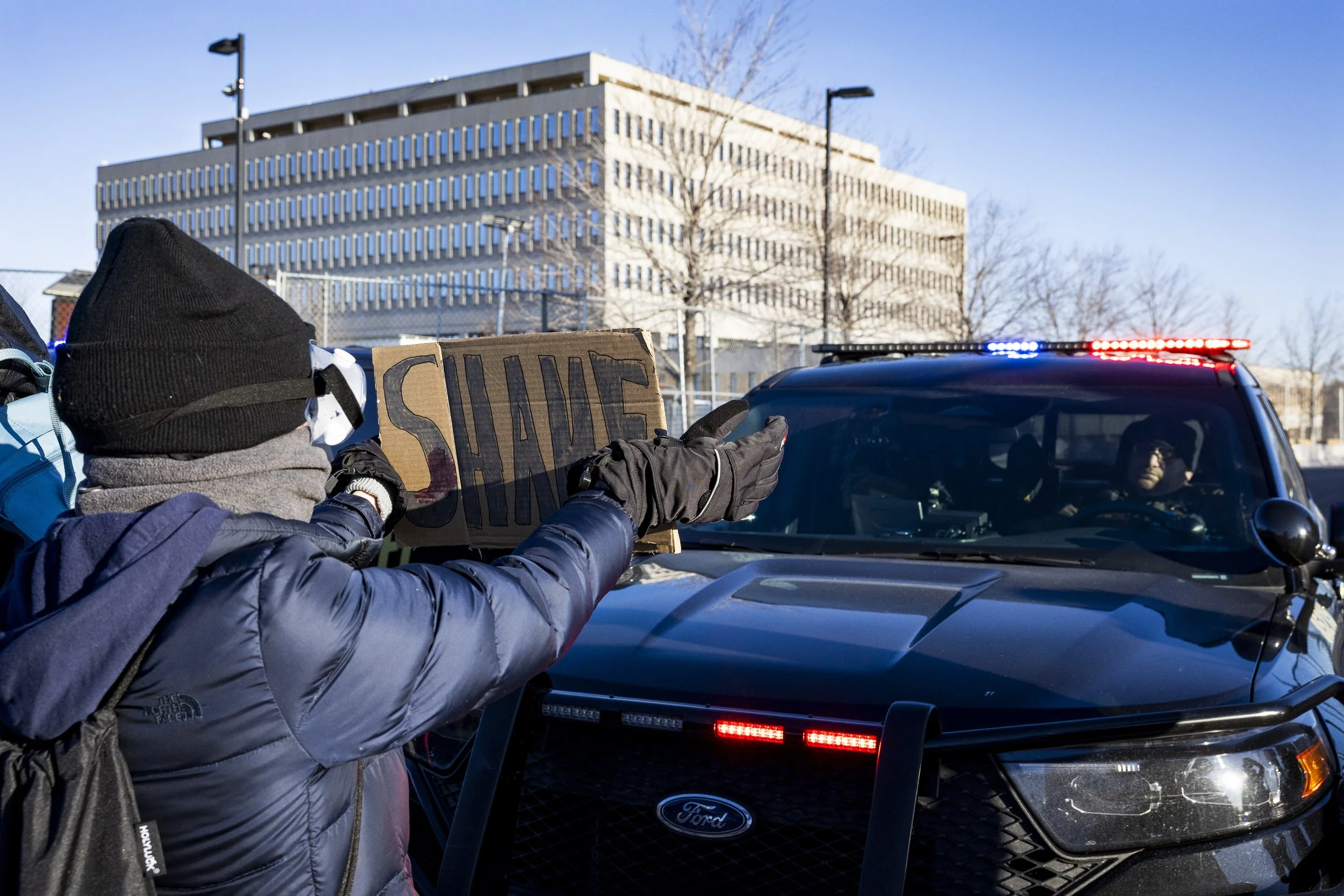  Protester holds a sign in front of law enforcement outside the Bishop Henry Whipple Federal Building in Minneapolis, Friday, Jan. 30, 2026. (Kayjel J. Mairena | The Corsair) 