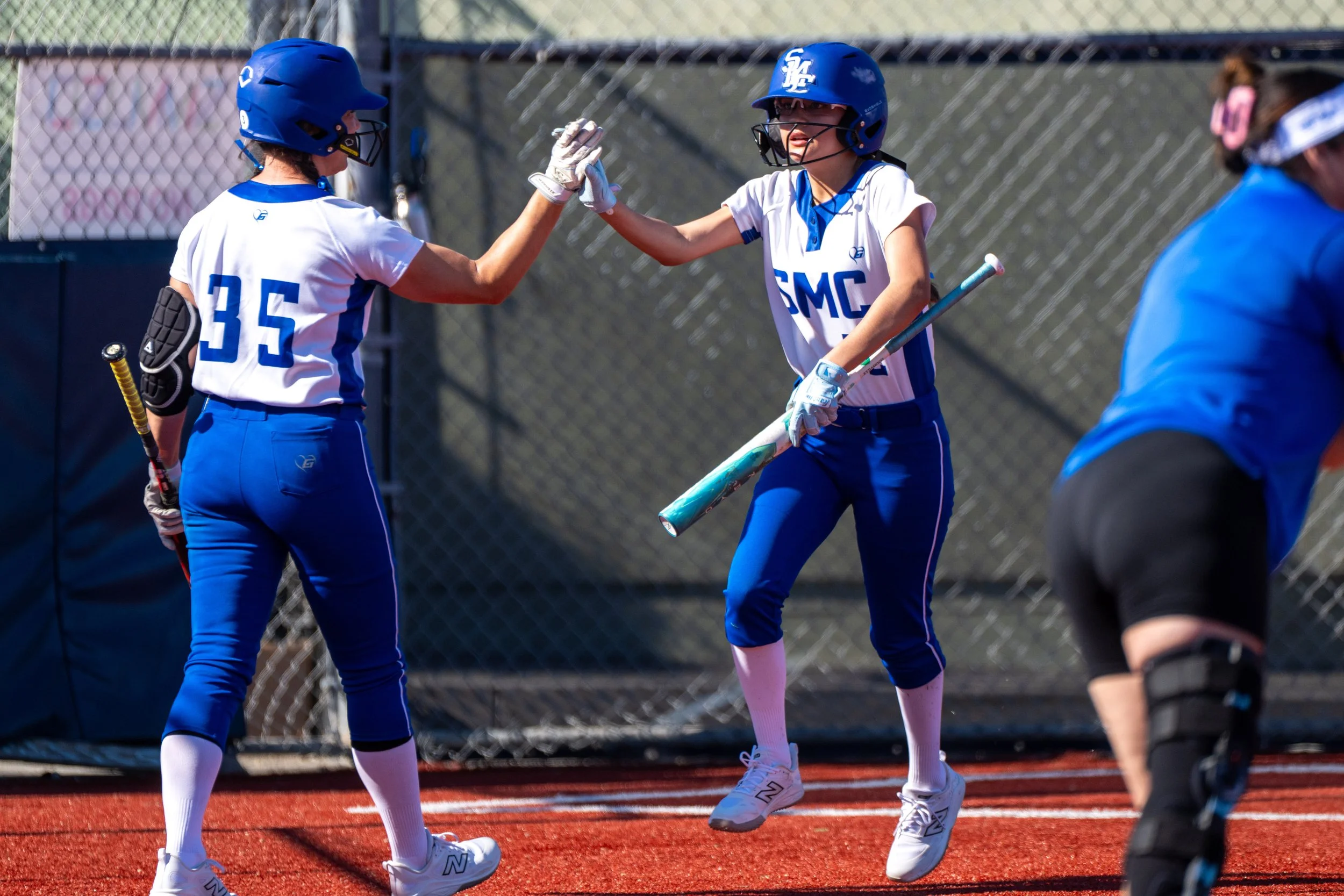  Santa Monica College (SMC) Corsair catcher Jodi Shuler (35) celebrating outfielder Danaly Santos (12) scoring during the game at Santa Monica, Calif., Thursday, Feb. 26, 2026. The Corsairs were defeated by the Valley College Monarchs 25-15. (Tom Ros
