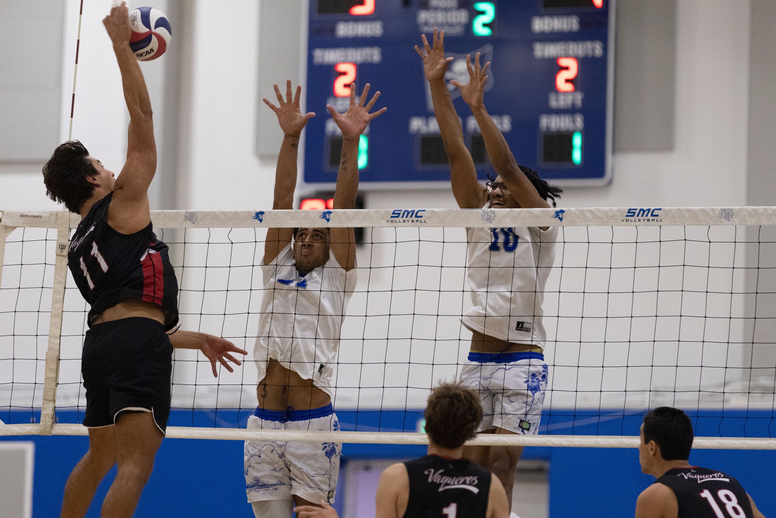  Santa Monica College (SMC) Corsair middle blocker / opposite hitter Jaydon Lyons (CQ) (#10) (R) and middle blocker / opposite hitter Samanu Hannemann (CQ) (#31) (L) attempting to block a spike from Santa Barbara City College (SBCC) Vaqueros outside 