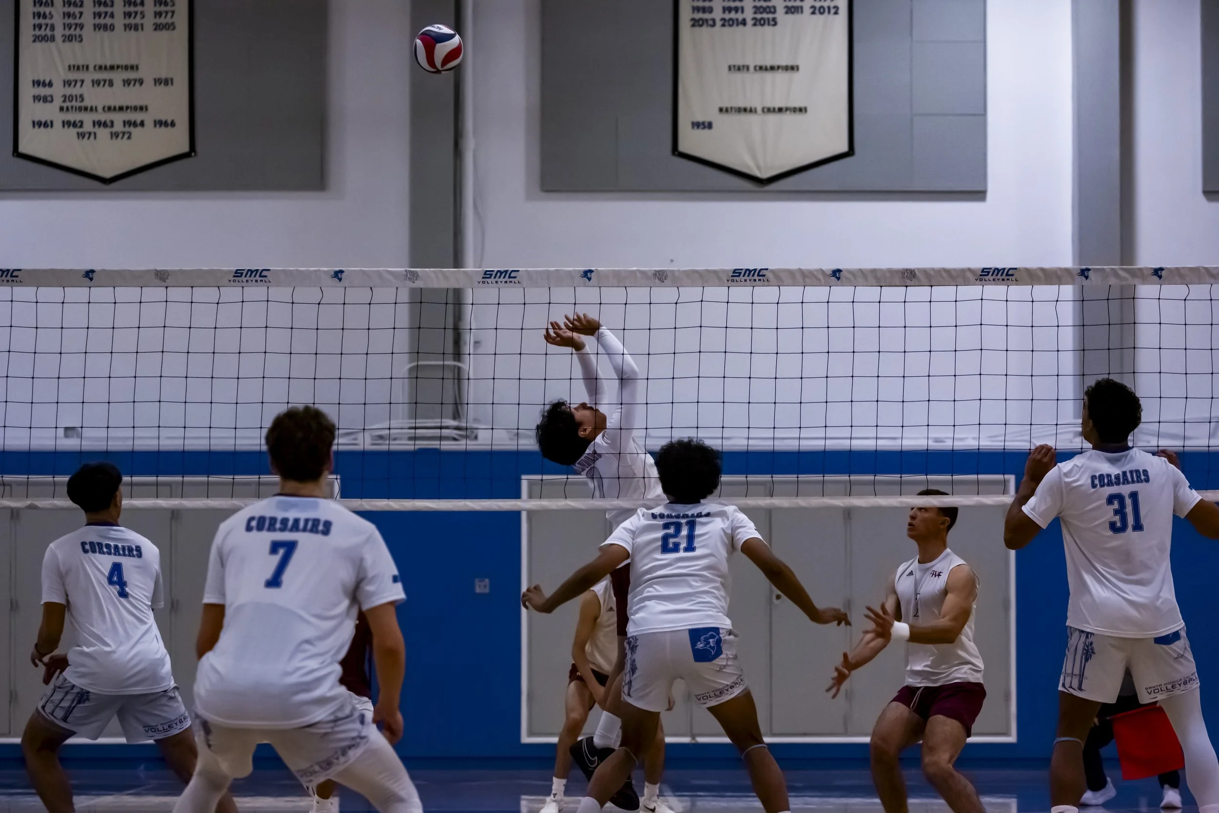  Antelope Valley College (AVC) Marauder Diego Ramirez (AVC) (#1)prepares to spike the ball as Santa Monica College (SMC) Corsair players RJ Carroll (SMC) (#4), Demian Anisimov (SMC) (#7), Soorya Raman (SMC) (#21) and Samanu Hannemann (SMC) (#31) prep