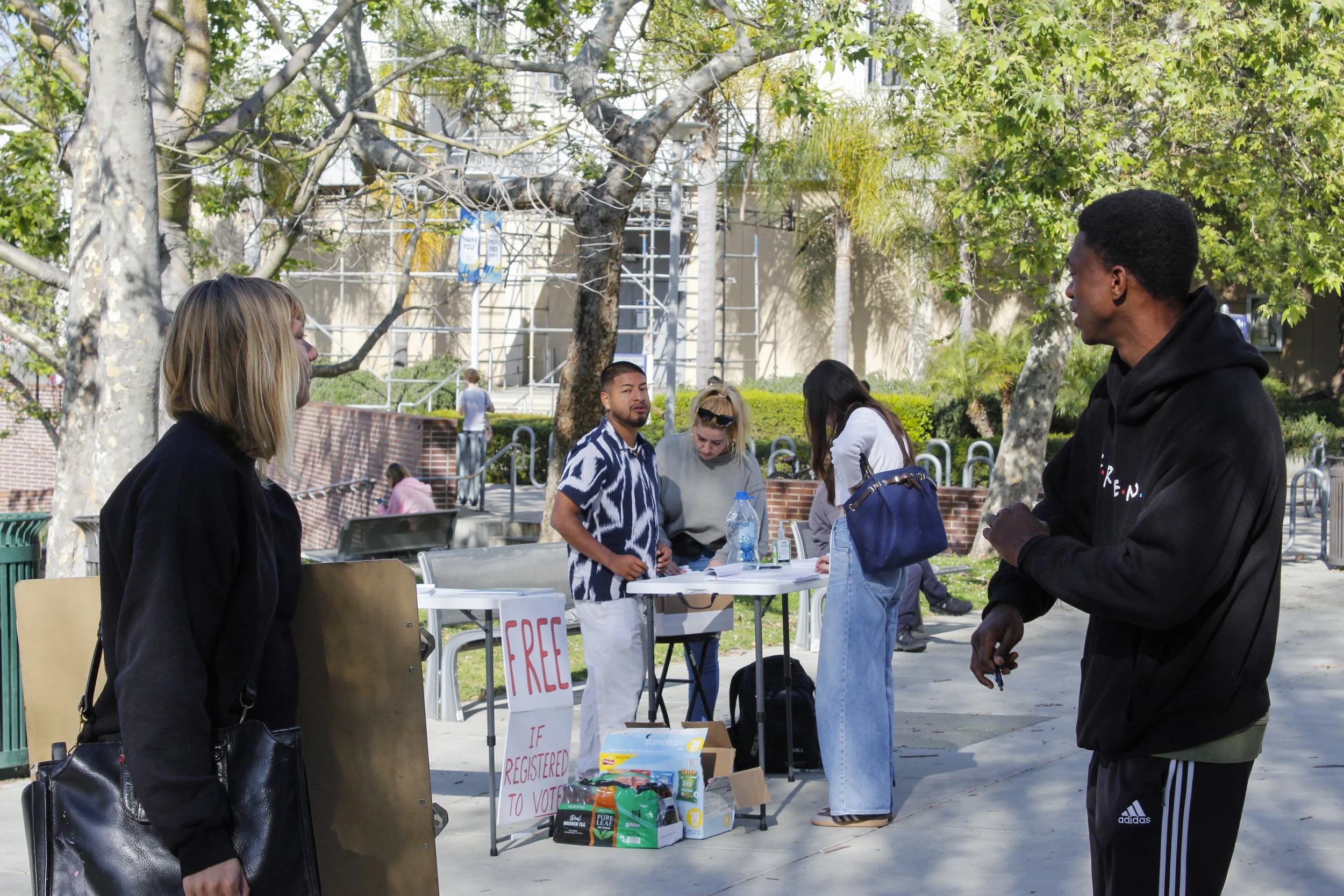  Petitioner (right) attempts to convince \\\\Santa Monica College (SMC) student to sign petitions to “tax billionaires” in exchange for free snacks on the SMC main campus on Wednesday, Feb. 25, 2026. This tactic has been used in busy walkways on camp