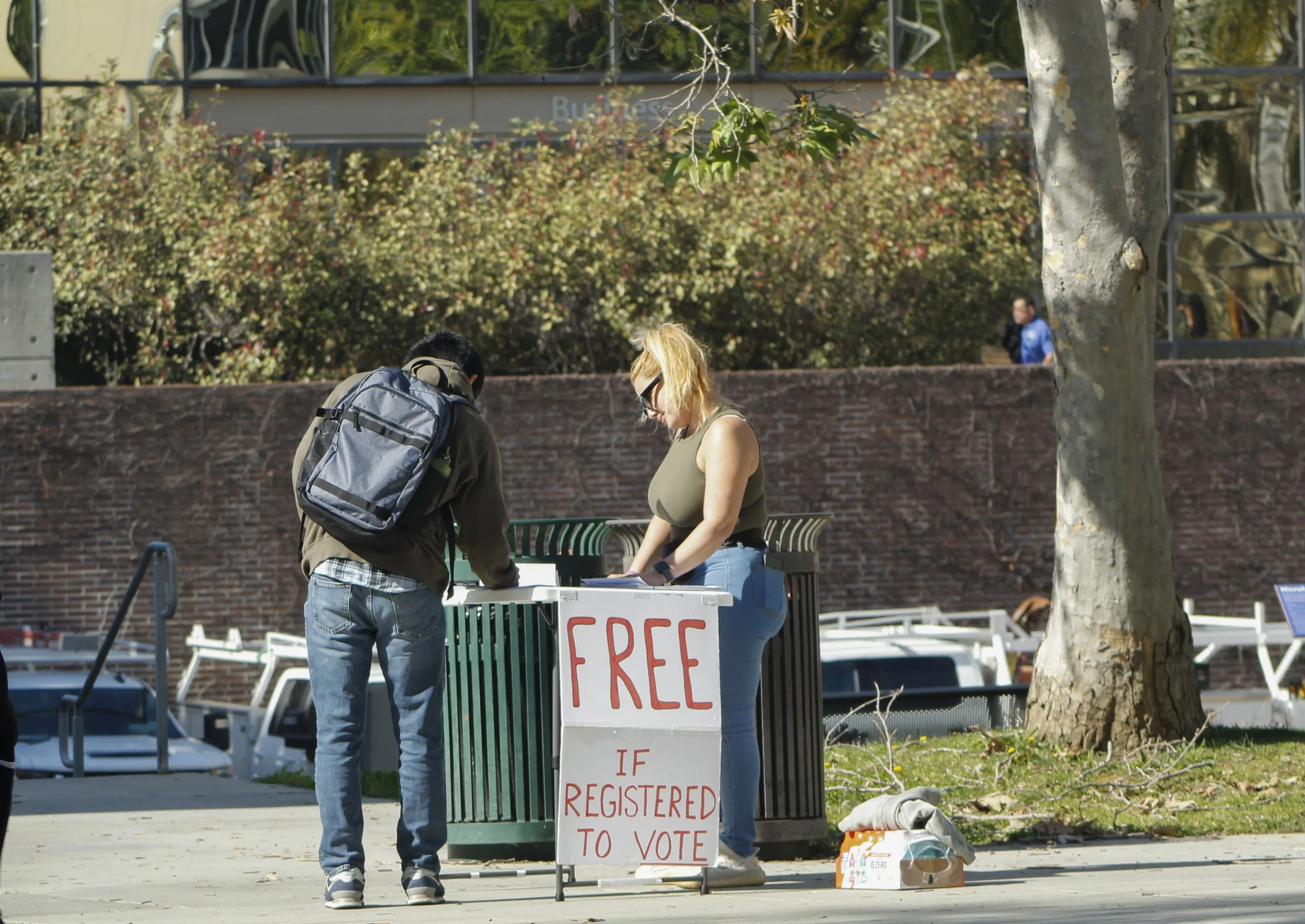  Petitioner (right) helps Santa Monica College (SMC) student fill out various petitions on SMC’s main campus Wednesday, Feb. 25, 2026. Sign displayed below offers free snacks (gatorade pictured here) if registered to vote, and thus able to sign petit