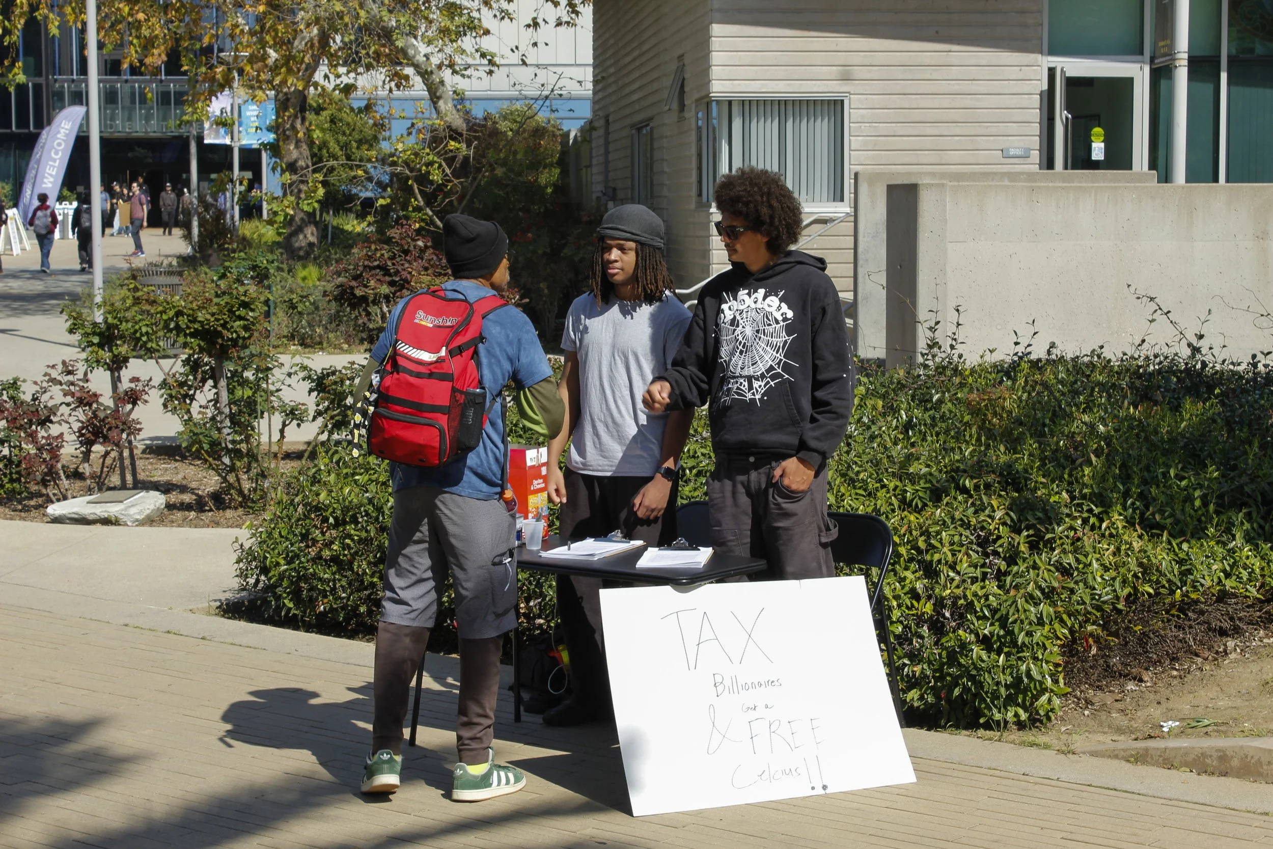  Petitioners (right) thank Santa Monica College (SMC) student for signing petitions to “tax billionaires” in exchange for free Celsius on the SMC main campus on Wednesday, Feb. 25, 2026. Some question the legality of bribes for students signatures on