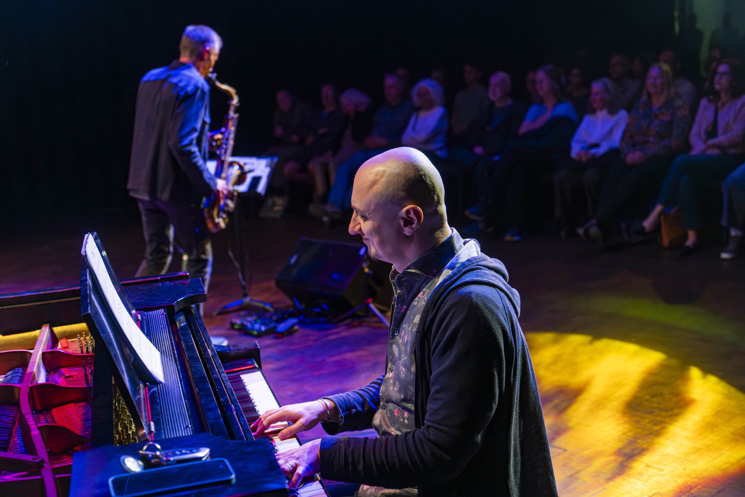  Ruslan Sirota on piano with Bob Reynolds on Saxophopne in the distance during thier performace at the Friday Jazz Series with Bob Reynolds inside the  Perofming Arts Center at Santa Monica College, in Santa Monica Calif., Friday, March 6, 2026 (Cors