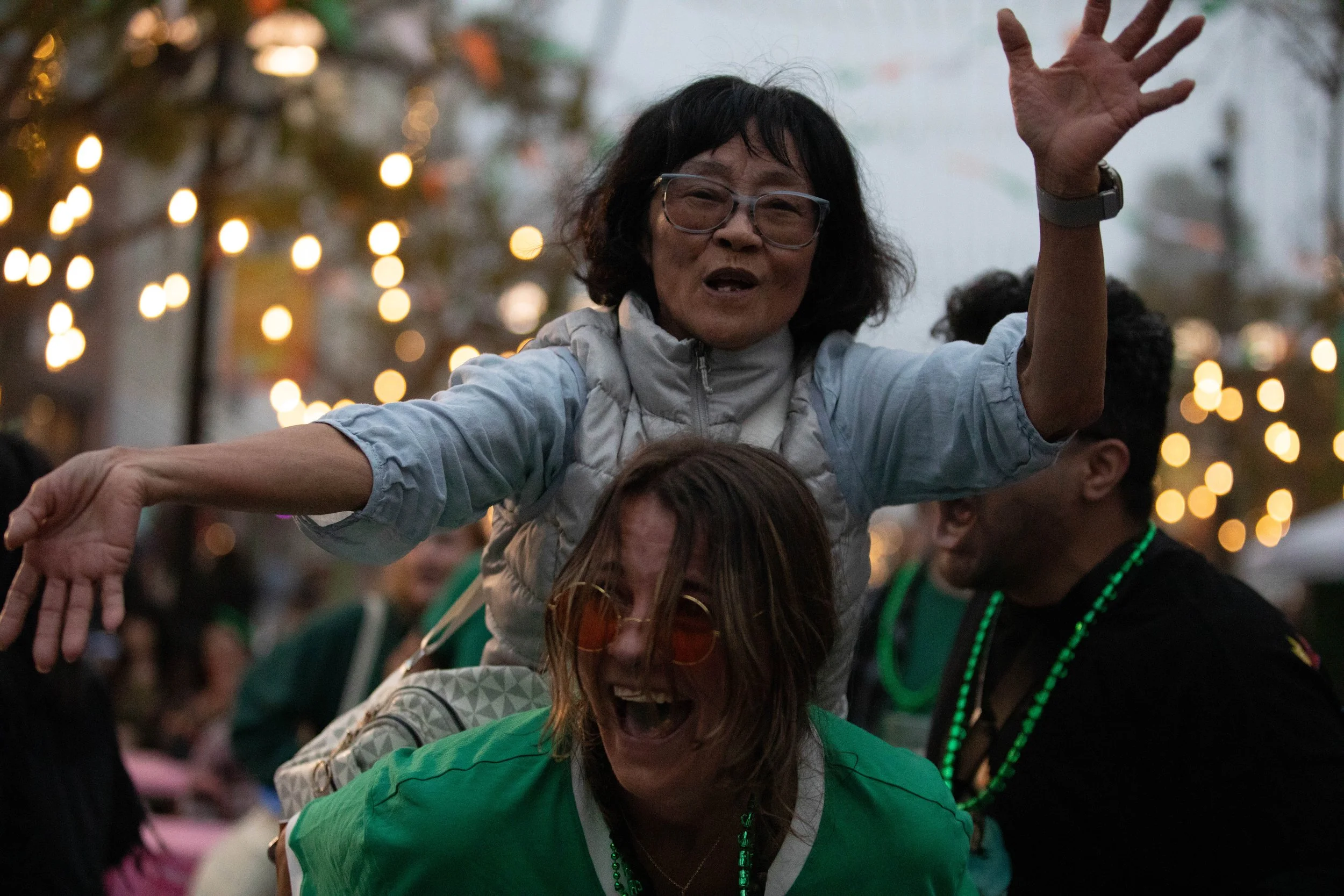  (L to R) Gianna Maldari (bottom) gives a piggyback ride to Josephine Nguyen (top) while Victor Carvajal sings along with Shamrock Sean and The Irish Cabbage Band at the St. Paddy's Day Celebration on the Promenade on March 14, 2026 on Third Street P