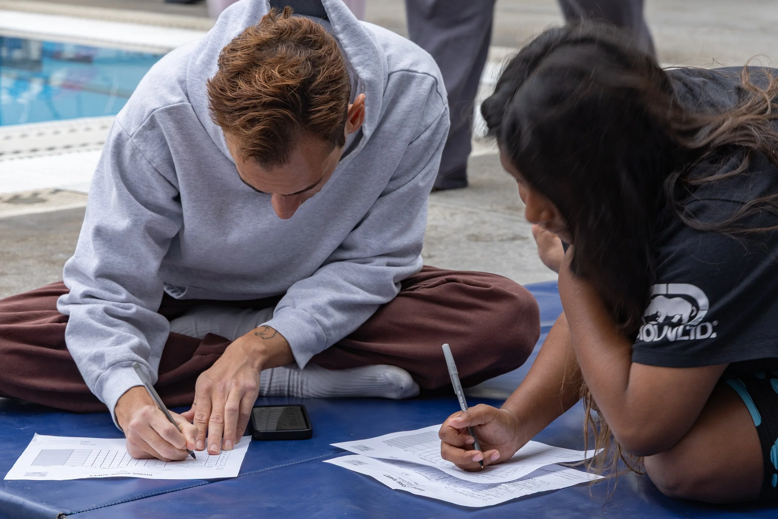  Christian Ventura (L) and Cindy Canseco (R), Santa Monica College (SMC) Swimming & Diving Corsairs fill out the Diving Score Sheet and decide on the order of their dives at the Western State Conference (WSC) #3 Swimming and Diving Meet on Friday, Ma