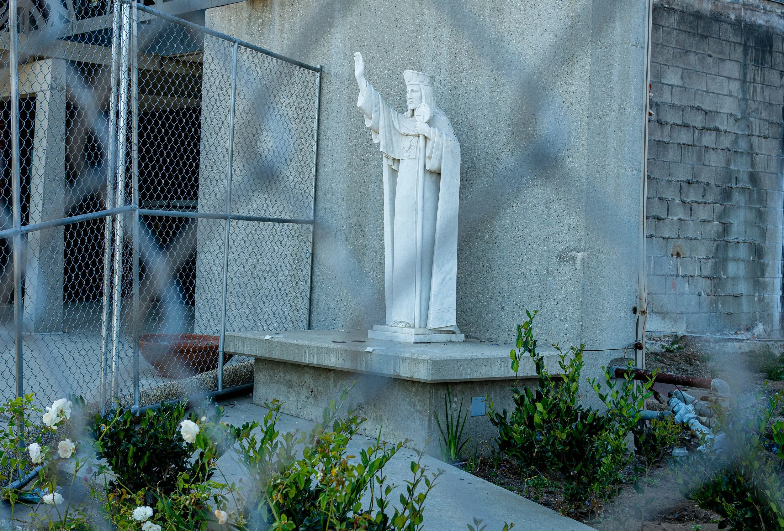  A statue of Jesus Christ stands behind a metal fence as rebuilding efforts begin at the site of the former Corpus Christi Church in Pacific Palisades, Monday, April 6, 2026, in Los Angeles, Calif. Originally built in 1950, the sanctuary was complete