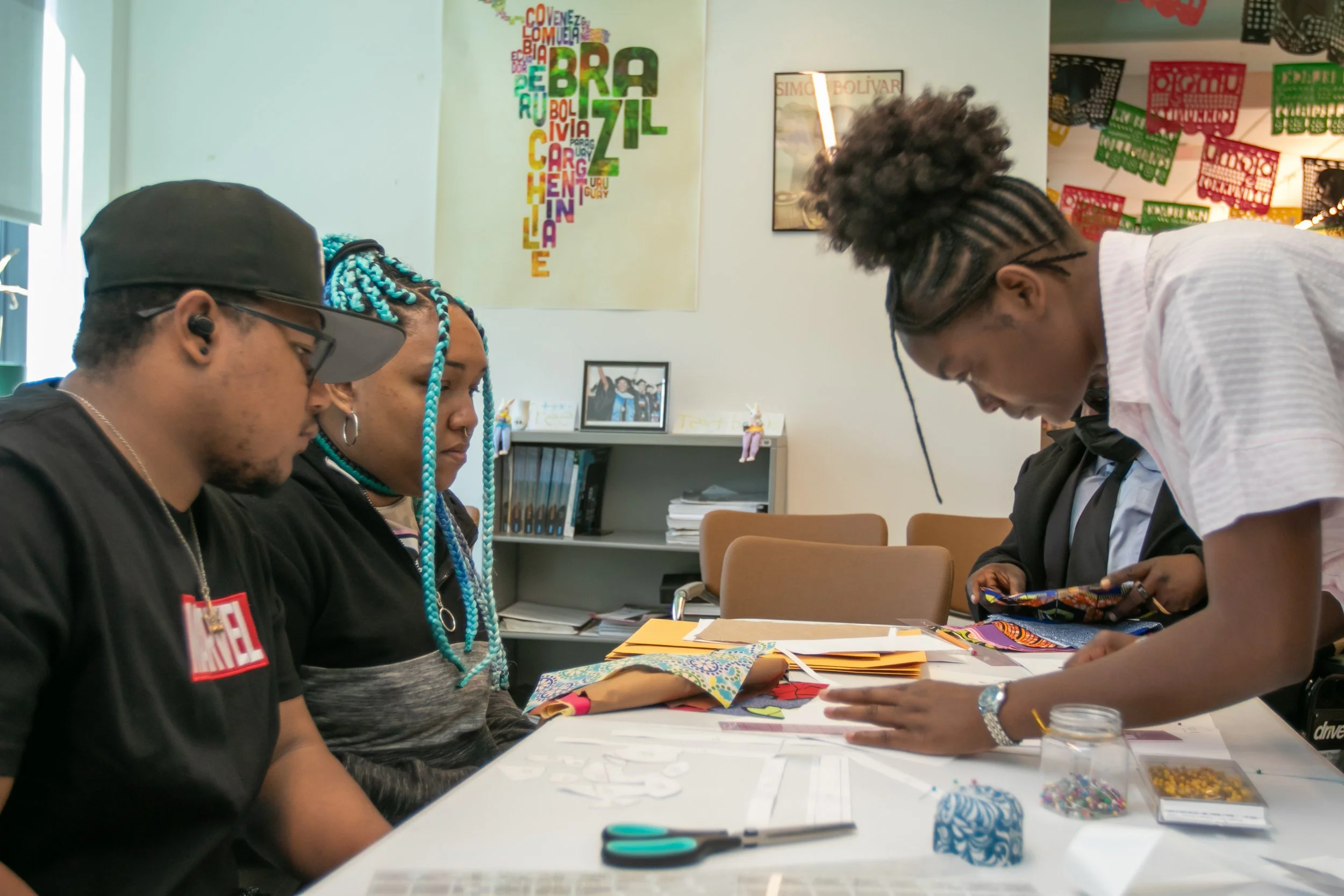  Santa Monica College (SMC) student Deborah Kobongo (R)  is showing how to set up the fabric to cut out their stencils to SMC student Elijah Boyd and his plus one Destinie Johnson (CQ) for the community quilt that they are putting together with the B