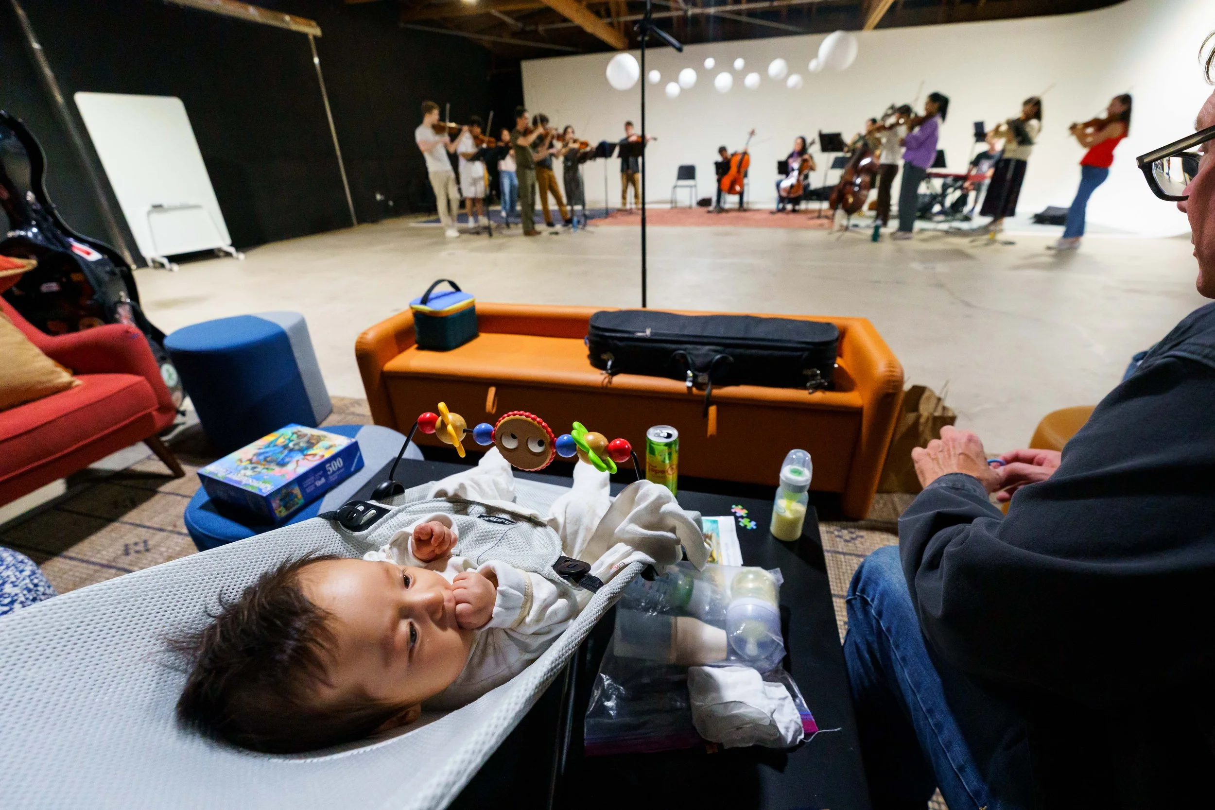  Baby Elian Gara (front), son of violinists Etienne Gara and YuEun Kim, during Delirium Musicum's (DM) rehearsal at Global Arts in Los Angeles, attended by philosophy professor Jay Conway (R), Friday, March 27, 2026. DM rehearsed Kodály's Intermezzo 