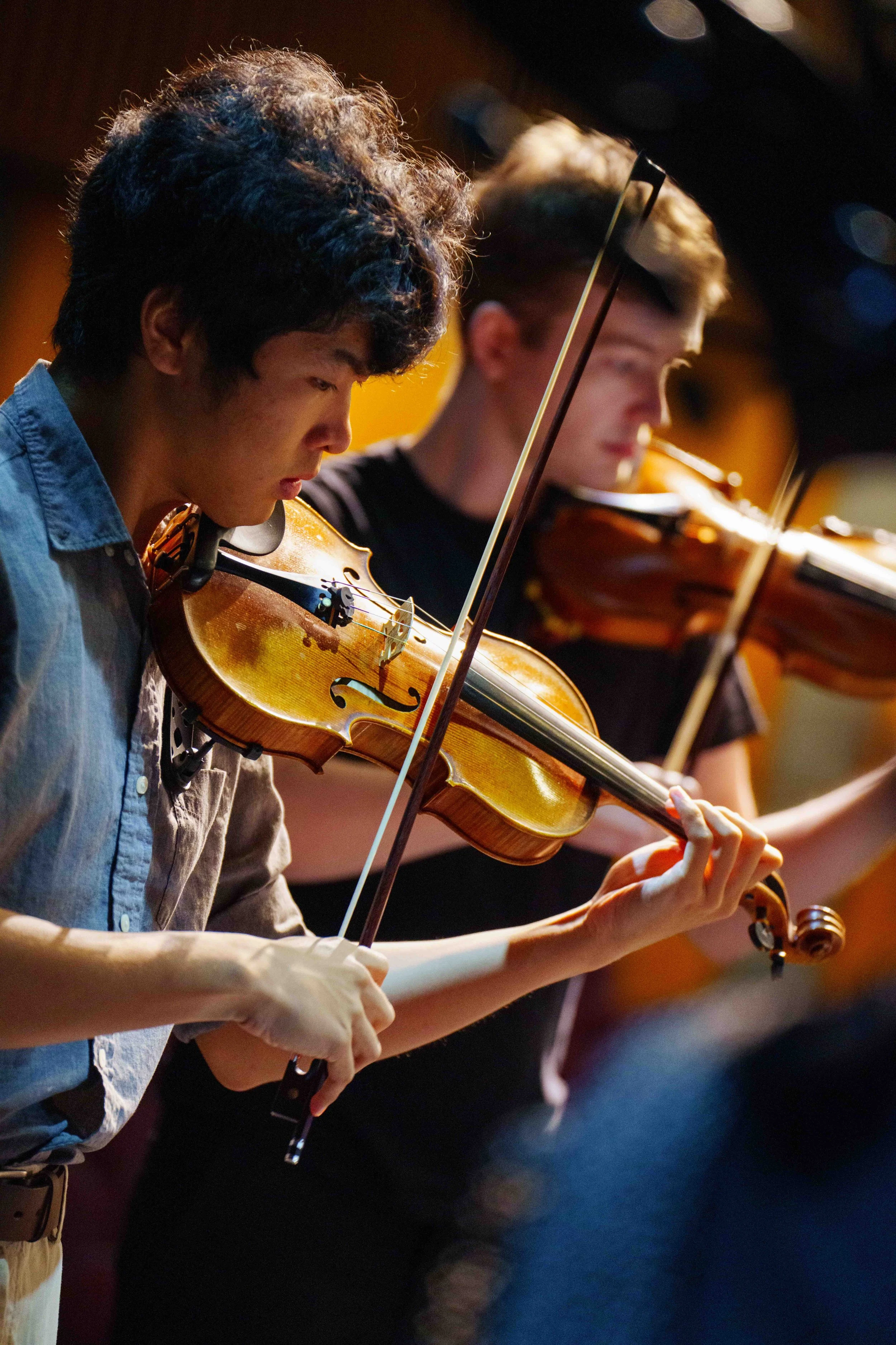  (L-R) Violinists Juchao Zhao and Misha Vayman rehearse at Théâtre Raymond Kabbaz in Los Angeles on Wednesday, March 25, 2026. Zhao's violin was a gift from his parents after he graduated with his Master's Degree after six years studying at The Juill