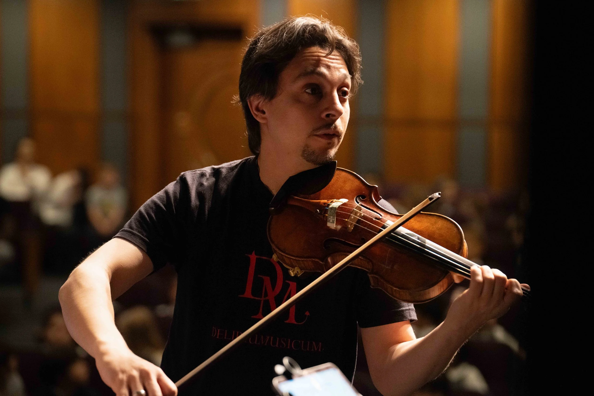 Violinist Etienne Gara rehearses with Delirium Musicum at Théâtre Raymond Kabbaz in Los Angeles, Wednesday, March 25, 2026, watched in the audience by visiting students of Le Lycée Français de Los Angeles. “People love something new,” Gara said of m