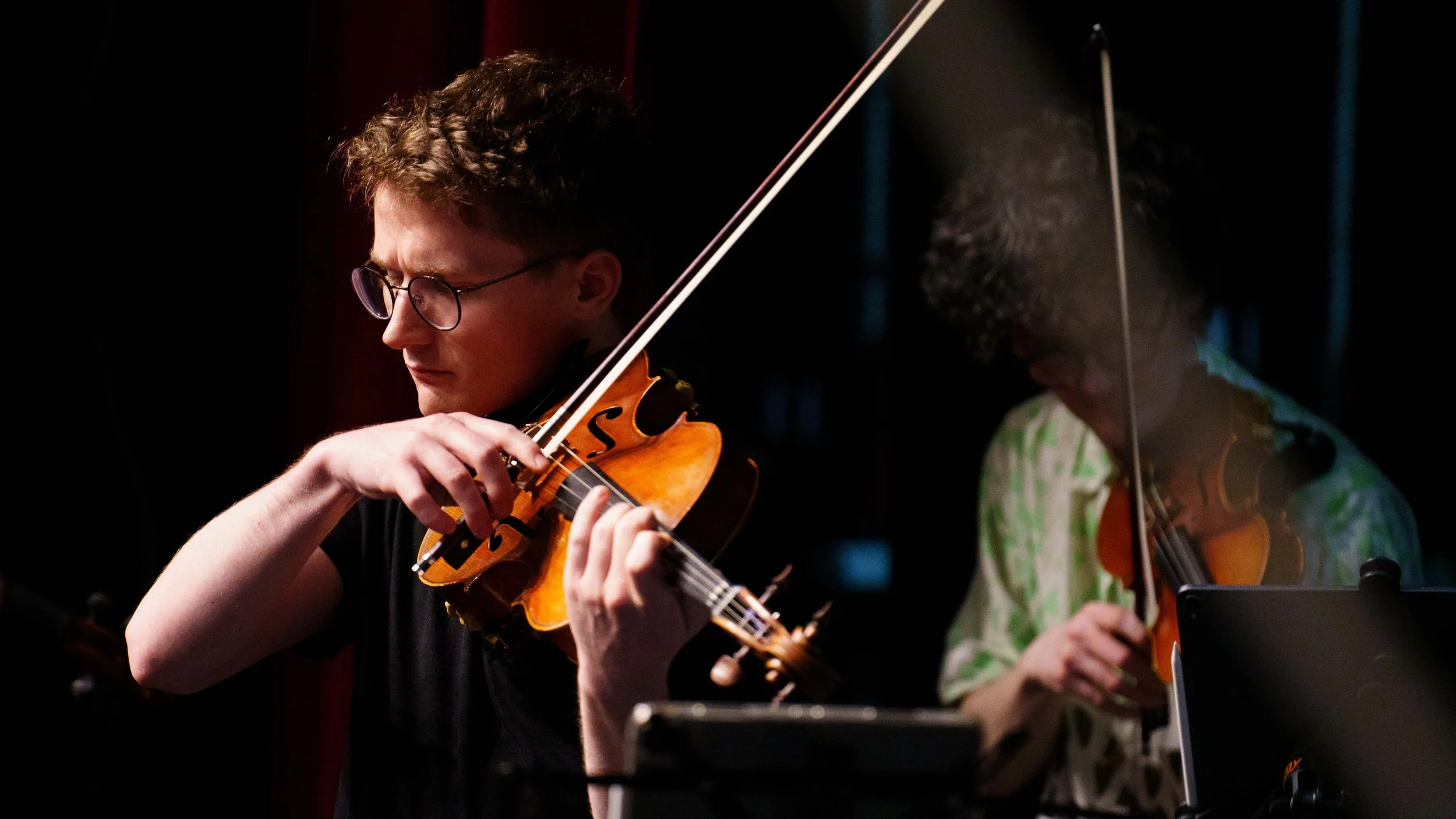  (L-R) Violist Chris Broyles and violinist Evan Hjort rehearse Bach's Brandenburg concerto No. 3 at Théâtre Raymond Kabbaz in Los Angeles on Wednesday, March 25, 2026. Hjort said, "Art arising from necessity is just a thing. It's like my mantra these