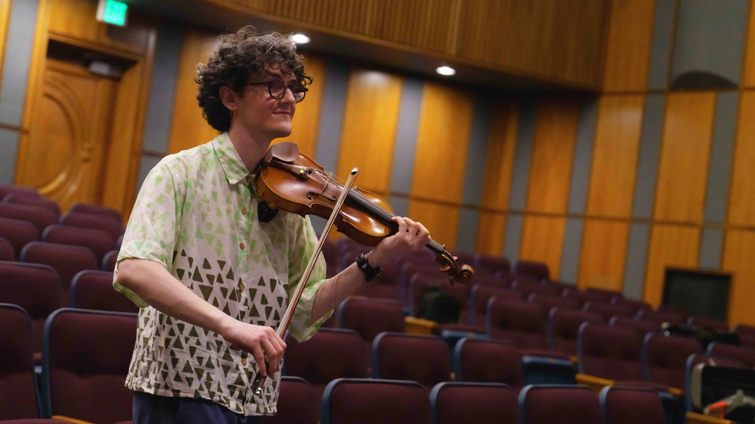  Seattle-based violinist Evan Hjort listens and demonstrates from the audience during rehearsal at Théâtre Raymond Kabbaz in Los Angeles, Wednesday, March 25, 2026. "The thing that that I can say bothers me most about just the classical world is the 
