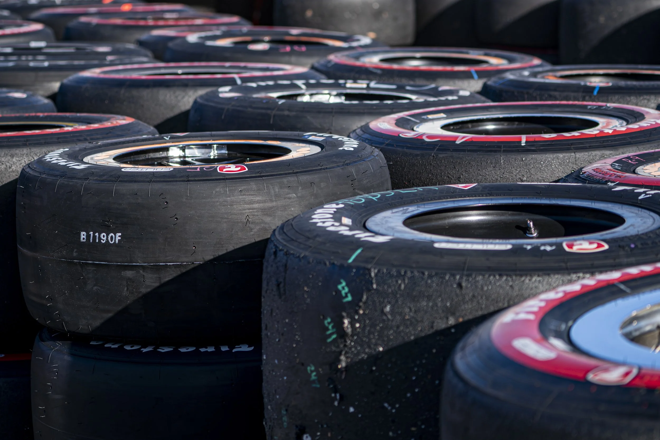  Stacks of "Hot" (used) custom sticky Firestone tires in the Paddock area of the after the final race of the Acura Grand Prix, red-sidewall tires known as "alternate" tires provide superior grip and faster lap times campared to the black-sidewall "pr