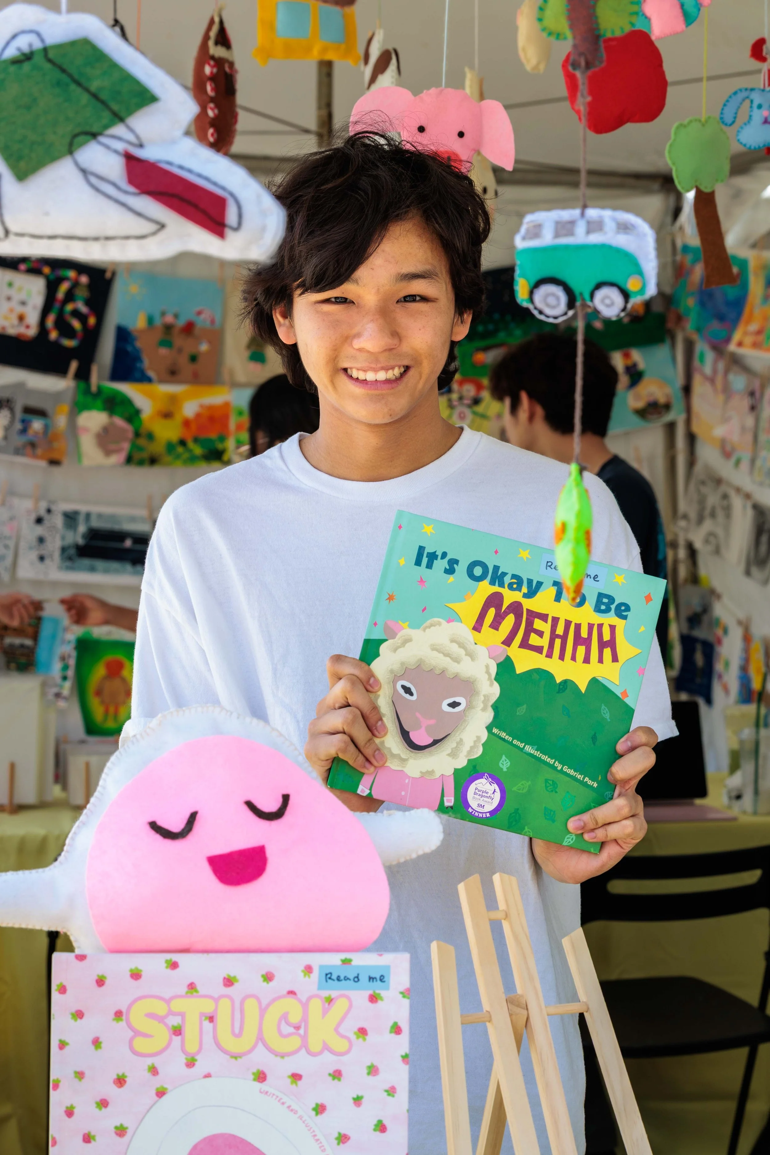  16-year-old student Gabriel Park holds up his book at the "Lumiere Picture Book by Kids" exhibitor tent during the Los Angeles Times Festival of Books held at University of Southern California in Los Angeles, Sunday, April 19, 2026. This year’s two-
