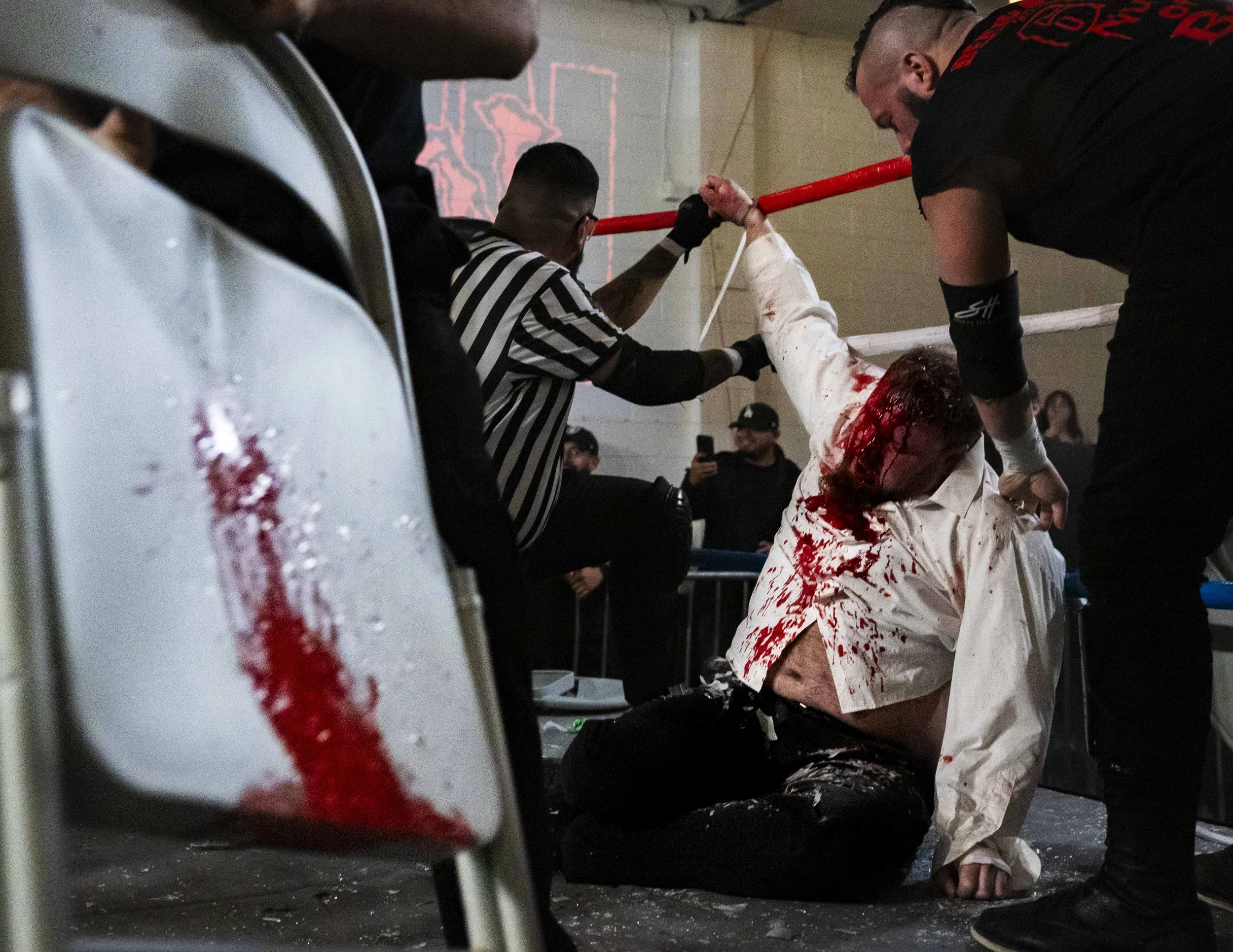  Referee Mike Valencia (L) unties deathmatch wrestler Phil Insane (R) from the ring after he was attacked for announcing his medically induced retirement inside the LA Church in Los Angeles on Saturday, Jan. 17, 2026. (Kayjel J. Mairena | The Corsair