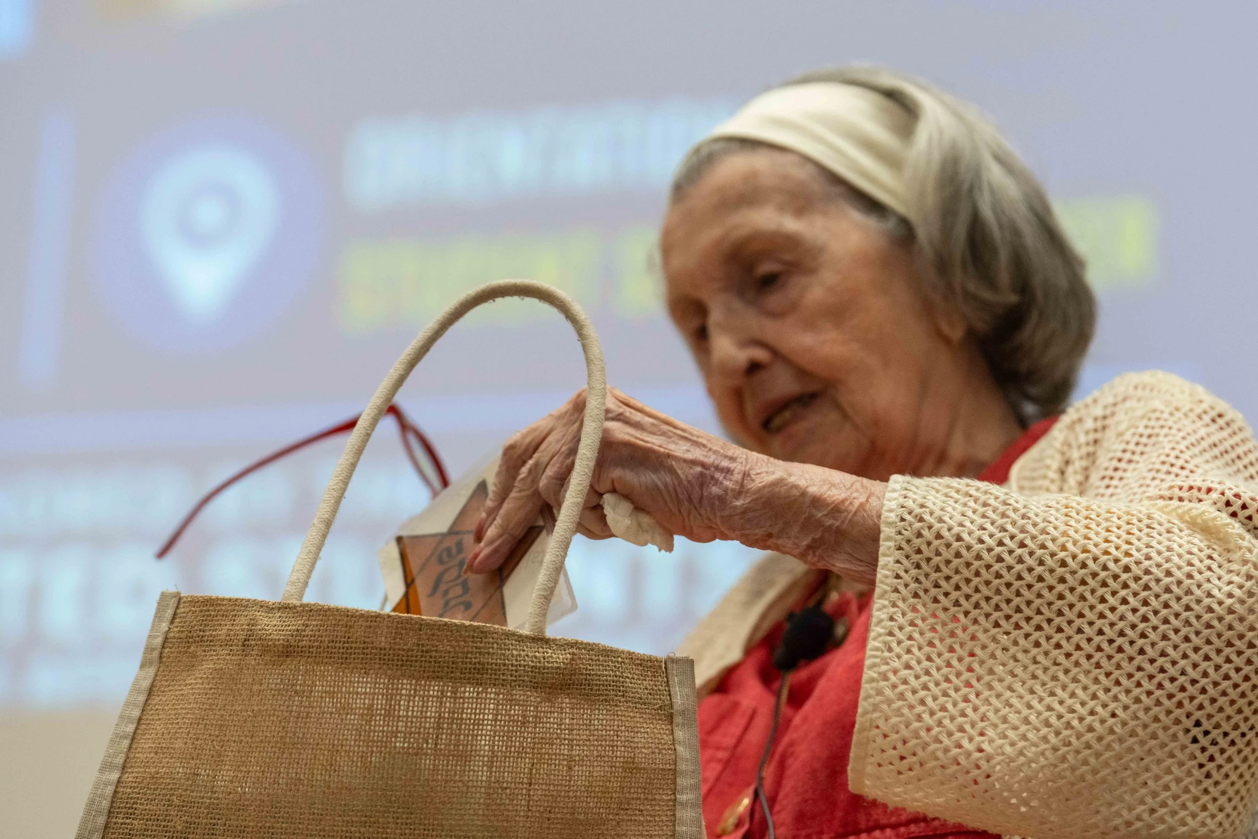  Holocaust survivor Mary Bauer pulls a Jewish Badge out of her purse while giving a presentation at Santa Monica College in the Orientation Hall at the Welcome Center in Santa Monica, Calif, Thursday, May 21, 2026. Bauer spoke about her own experienc