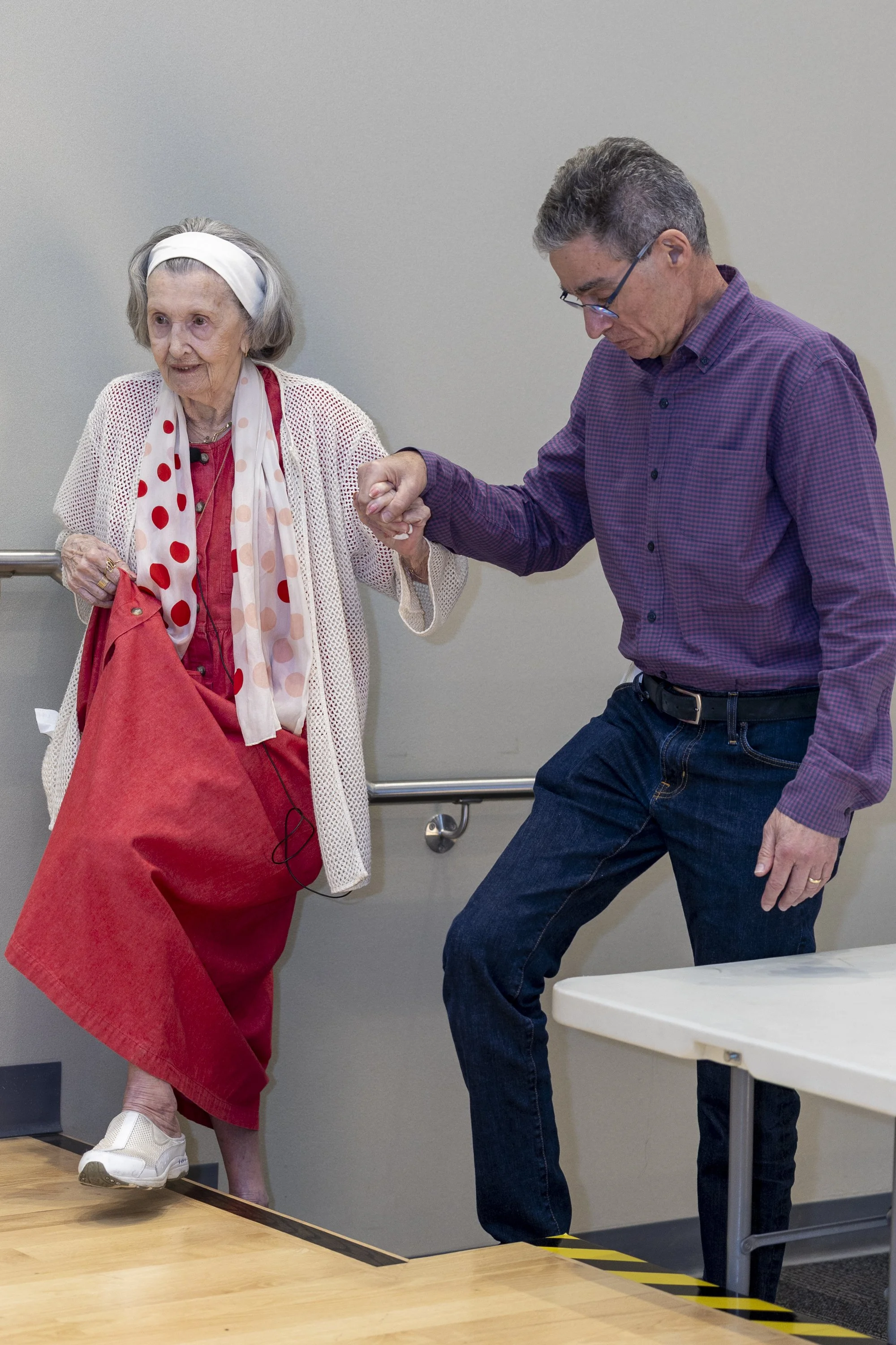  (L-R) Mary Bauer, a nearly 99-year-old Holocaust survivor, walks to the podium with the support of her longtime friend and Dean of Education Enterprise Mitchell Heskel to open the event ‘A Conversation with Holocaust Survivor Mary Bauer’ on Thursday