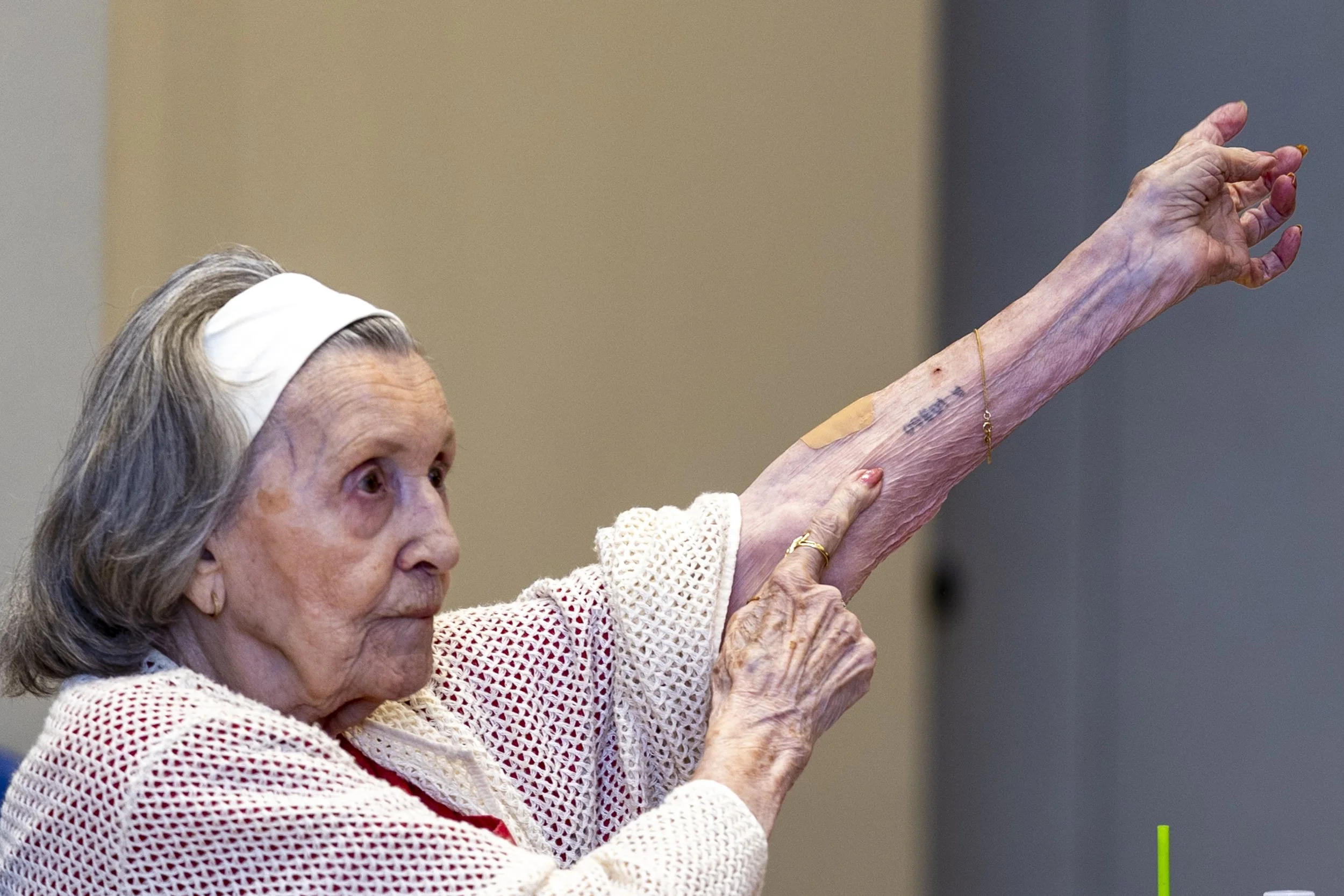  Mary Bauer, a nearly 99-year-old Holocaust survivor, shows her tattoo on her left arm during the event ‘A Conversation with Holocaust Survivor Mary Bauer’ on Thursday, May 21, 2026, at Santa Monica College (SMC) Student Services Center, Orientation 
