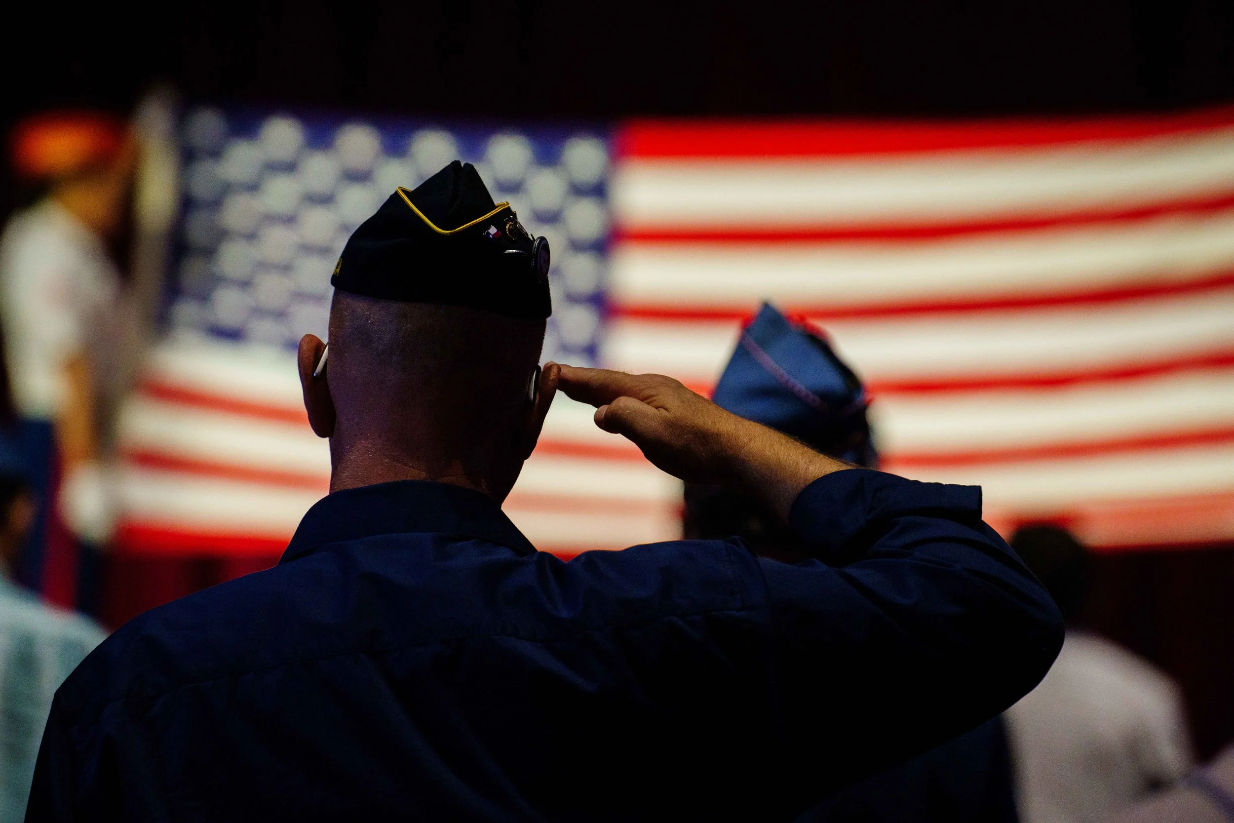  A member of the American Legion salutes an unfurled flag held by the Color Guard during a Celebration of Life for retired Santa Monica College (SMC) Police Captain and U.S. Marine Corps veteran Jere Romano at the American Legion Hollywood Post 43 in