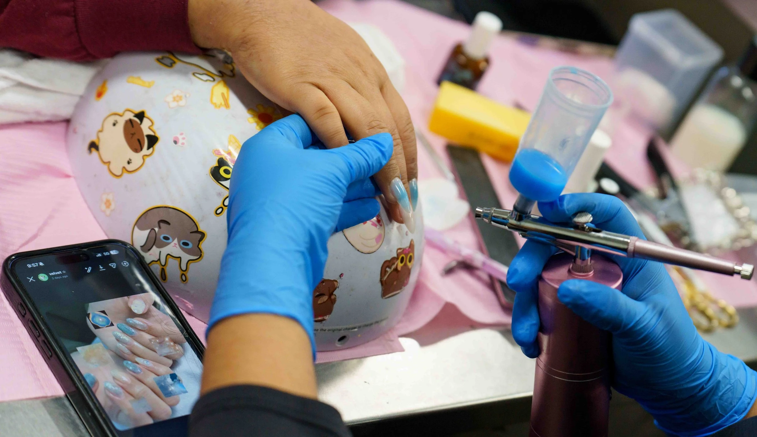  Second-year Santa Monica College (SMC) cosmetology major Lesli Stephani Vargas Martinez applies airbrush color to SMC student Nautica Ochoa’s nails inside the cosmetology department’s salon at the SMC Business Building in Santa Monica, Calif., Tuesd