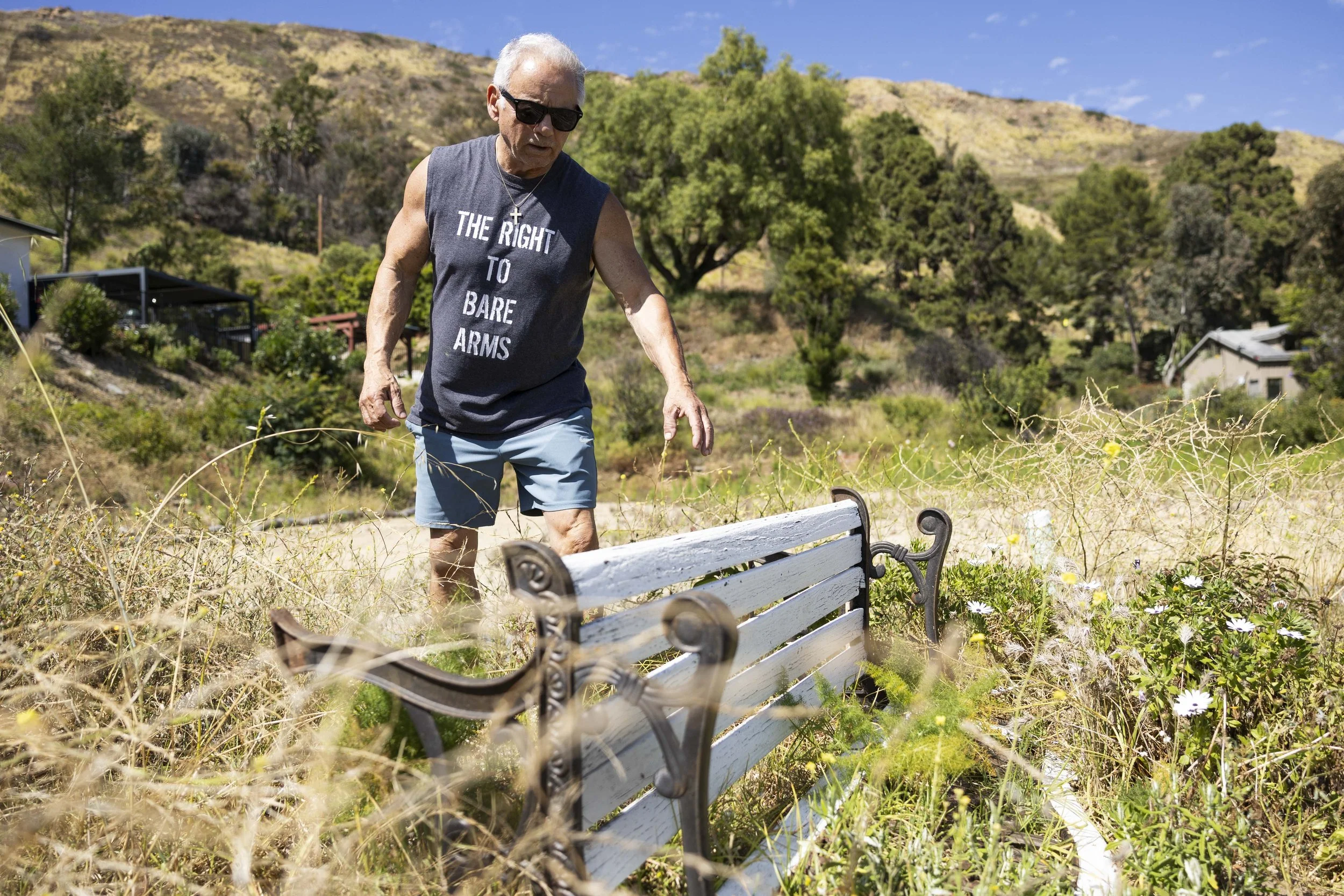  Joe D’Amore reaches for a bench in front of an empty lot in Malibu, Calif., on Friday, April 24, 2026, where his home stood until it was destroyed in the Palisades Fire in 2025. (Kayjel J. Mairena | The Corsair)  