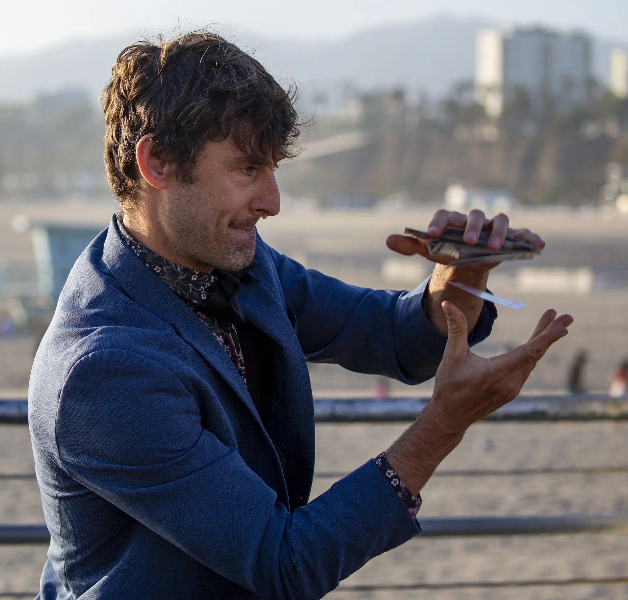  Street magician Jesse Mock makes a deck of cards appear to float upward from one hand to the other during a performance at the Santa Monica Pier in Santa Monica, Calif., on Friday, May 1, 2026. (Jinhao Tian | The Corsair) 