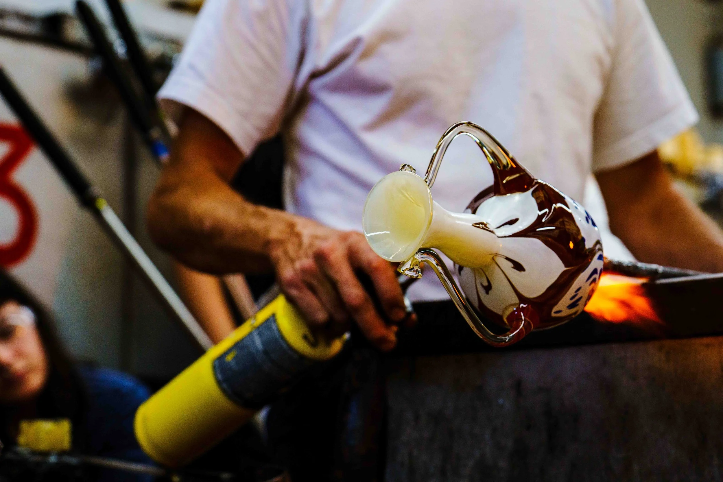  Los Angeles based glass and metalwork artist Evan Chambers applies a torch to his glass sculpture inside the Santa Monica College (SMC) glass studio hot shop in Santa Monica, Calif., watched by SMC student Leah Zarrabian (L), for Santa Monica Colleg