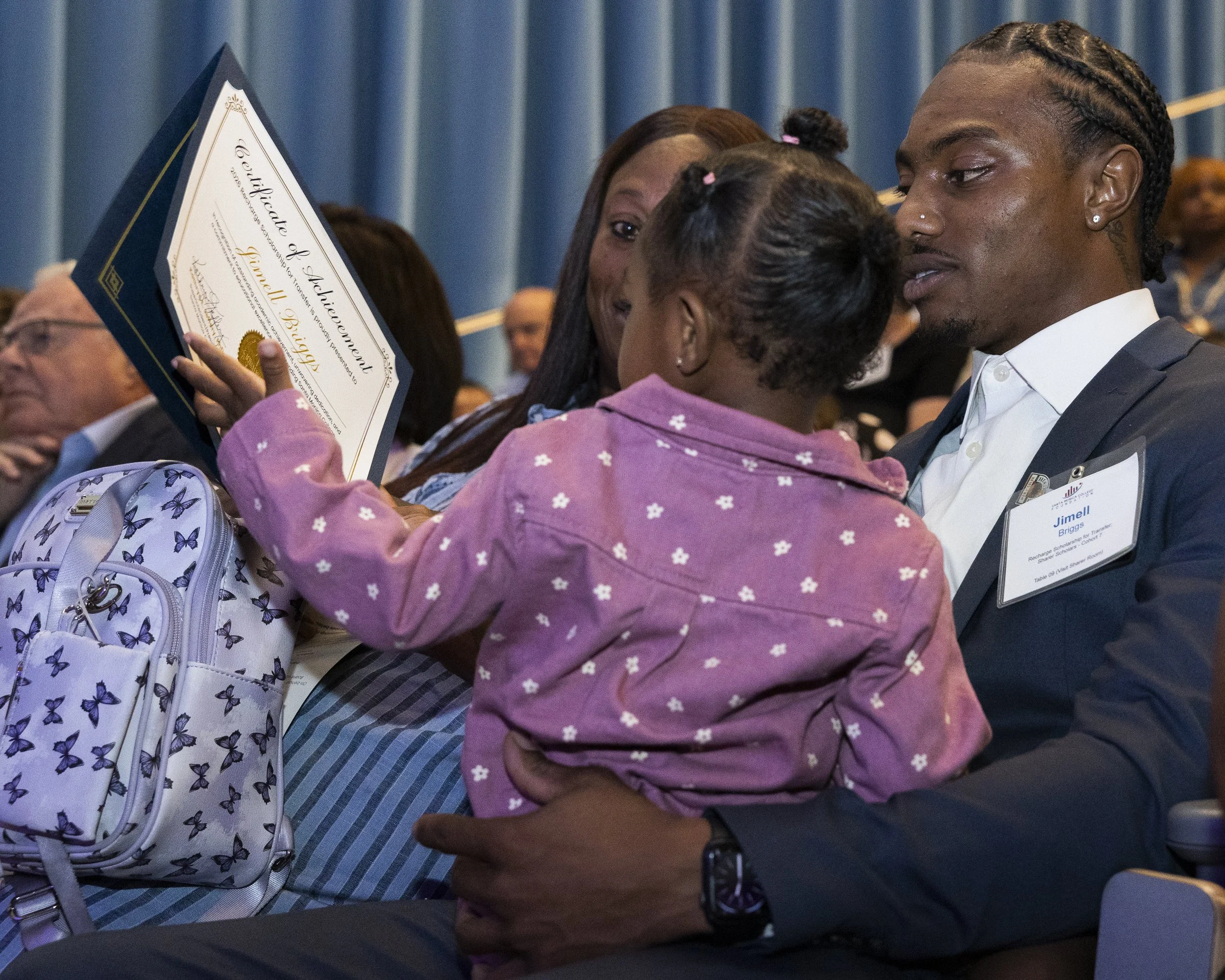  Santa Monica College student Jimell Briggs holds a child after receiving a certificate of achievement during the college’s scholarship and donor recognition event inside the Student Services Center in Santa Monica, Calif., on Friday, June 12, 2026. 